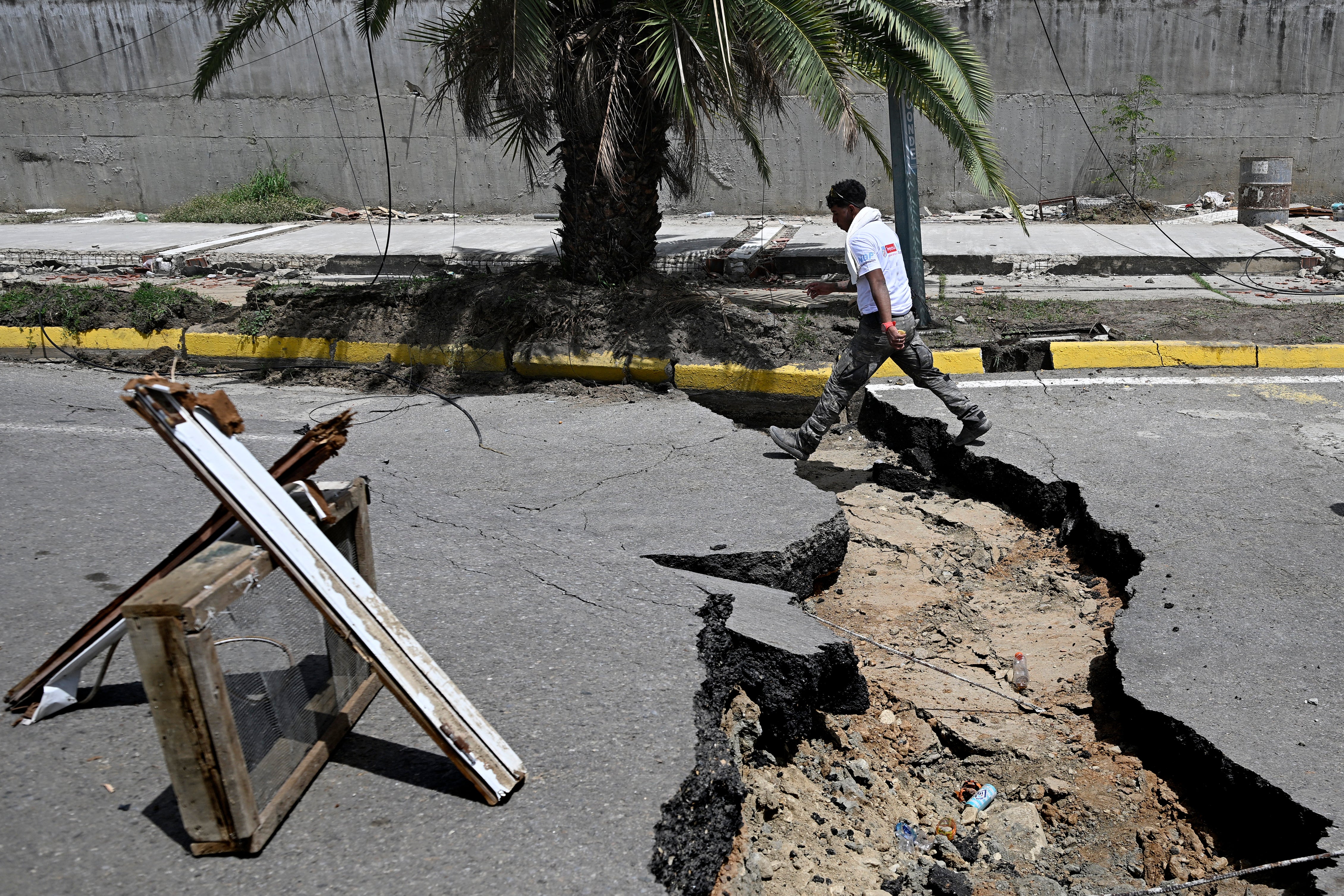 A man walks in a cracked street following a twin earthquake, in Los Corales (AFP/Getty)
