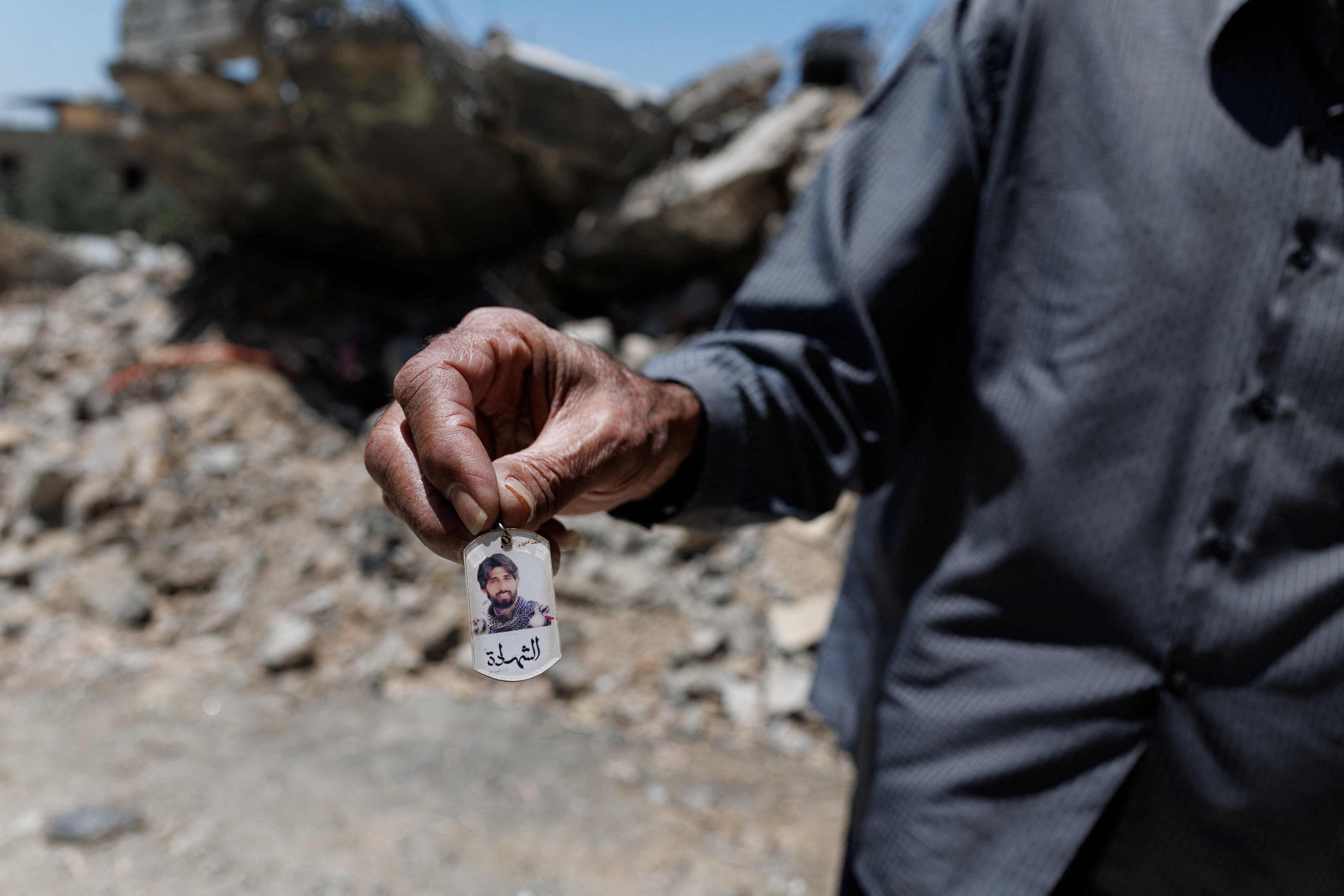 The man shows a photo of his son, who, according to him, was a Hezbollah fighter and was killed by an Israeli strike