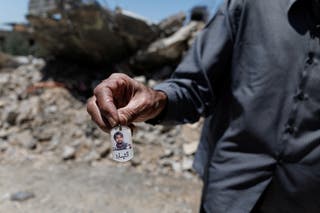 The man shows a photo of his son, who, according to him, was a Hezbollah fighter and was killed by an Israeli strike