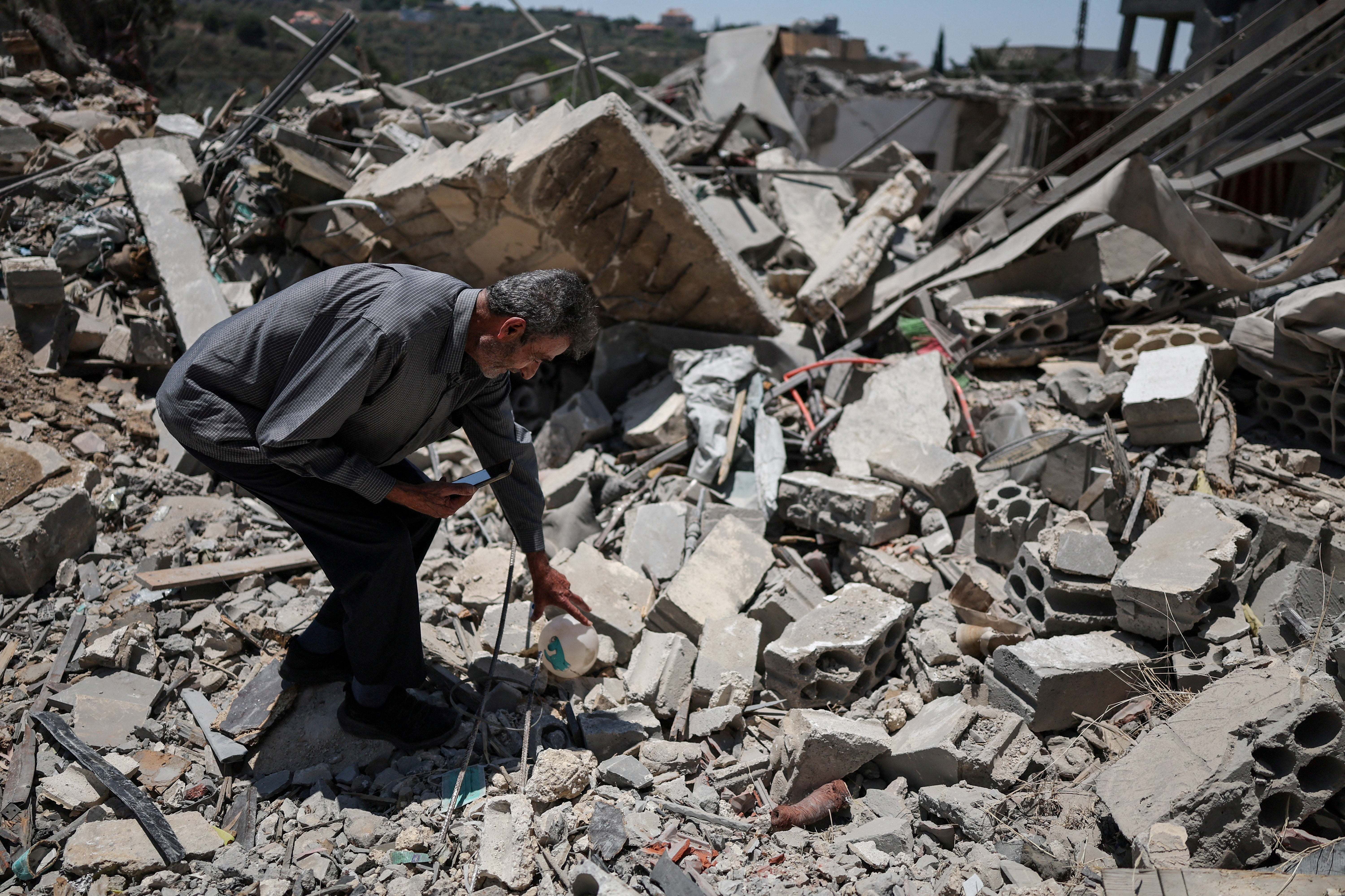 A 76-year-old displaced Lebanese man shows his house, destroyed by an Israeli airstrike on 25 June
