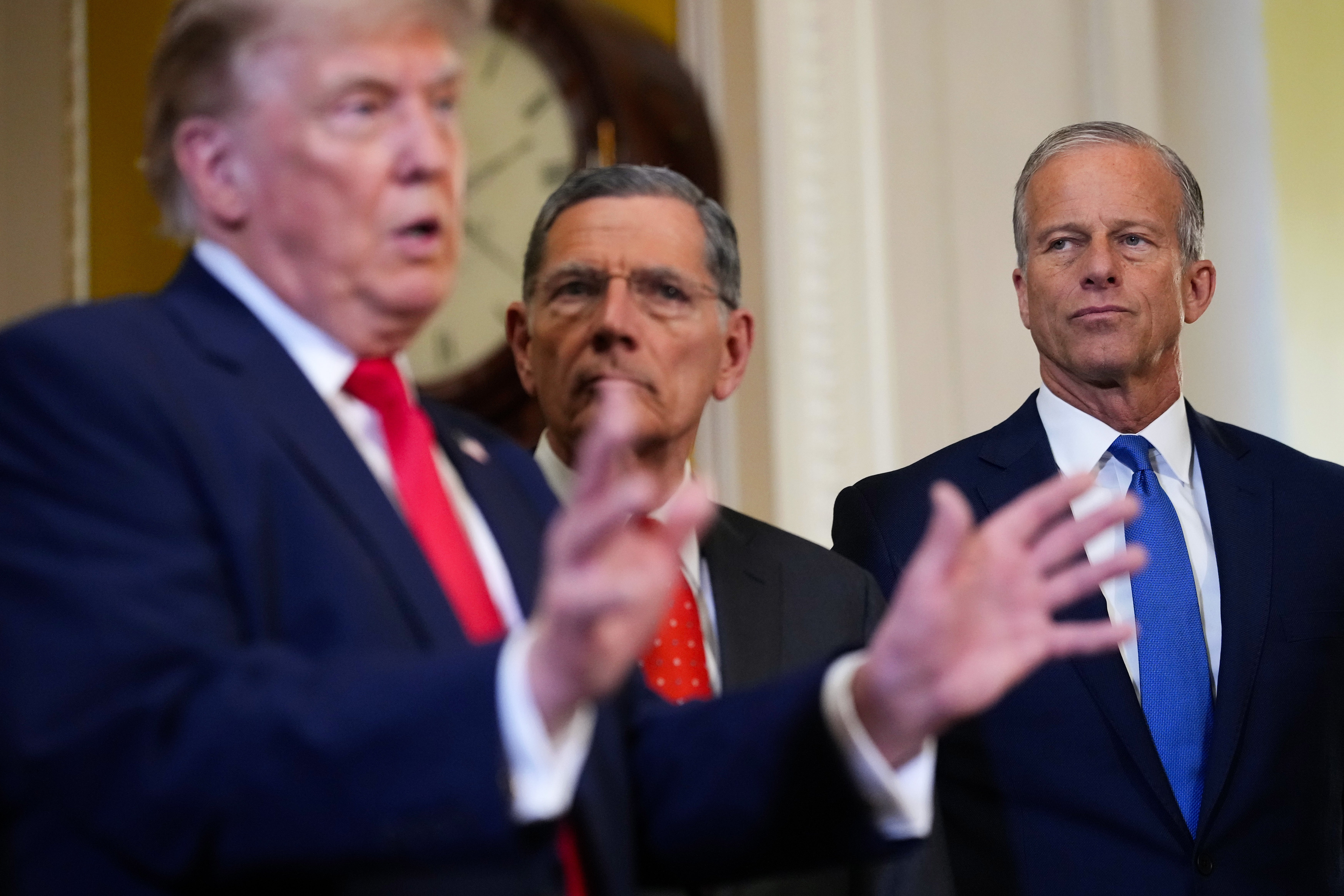President Donald Trump speaks to the media as U.S. Senate Majority Whip John Barrasso (R-WY) and U.S. Sen. Majority Leader John Thune (R-SD) look on after a meeting at the U.S. Capitol on June 24