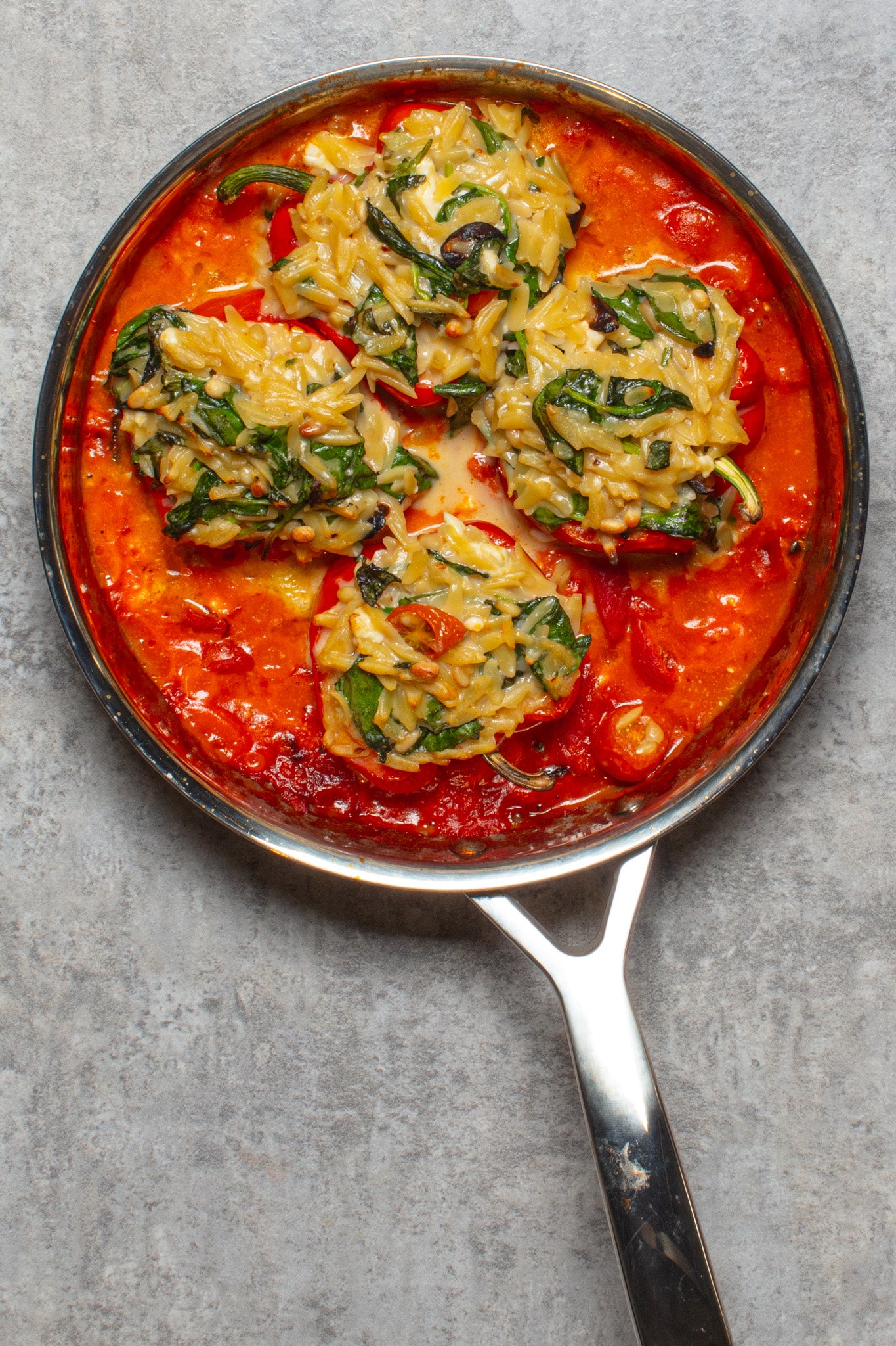 Choose the squattest, most even-bottomed peppers you can find – they’ll sit upright in the sauce rather than tipping their filling