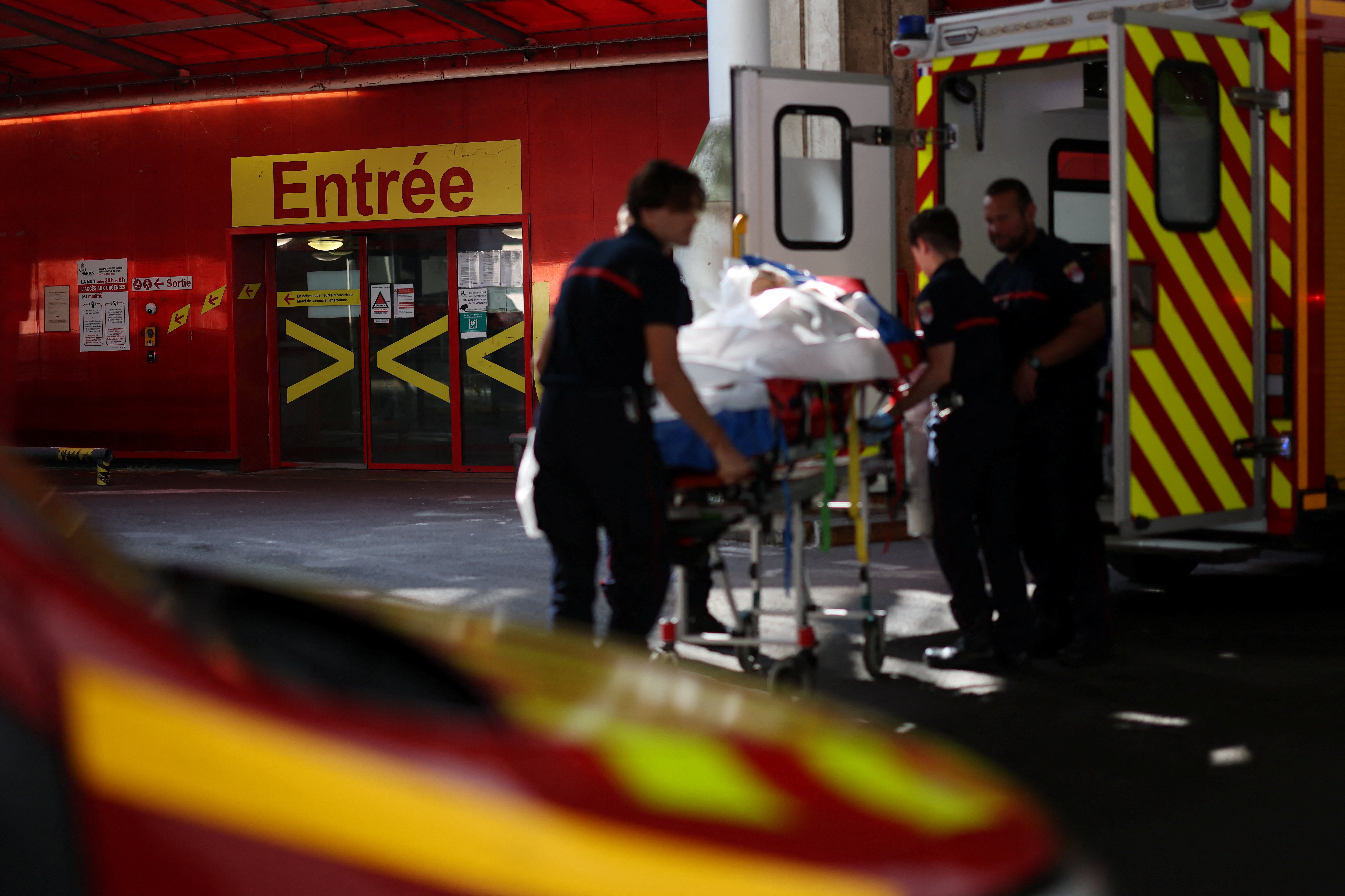 French firefighters arrive with a patient on a stretcher in Nantes on 26 June, amid a major heatwave sweeping France (Reuters)