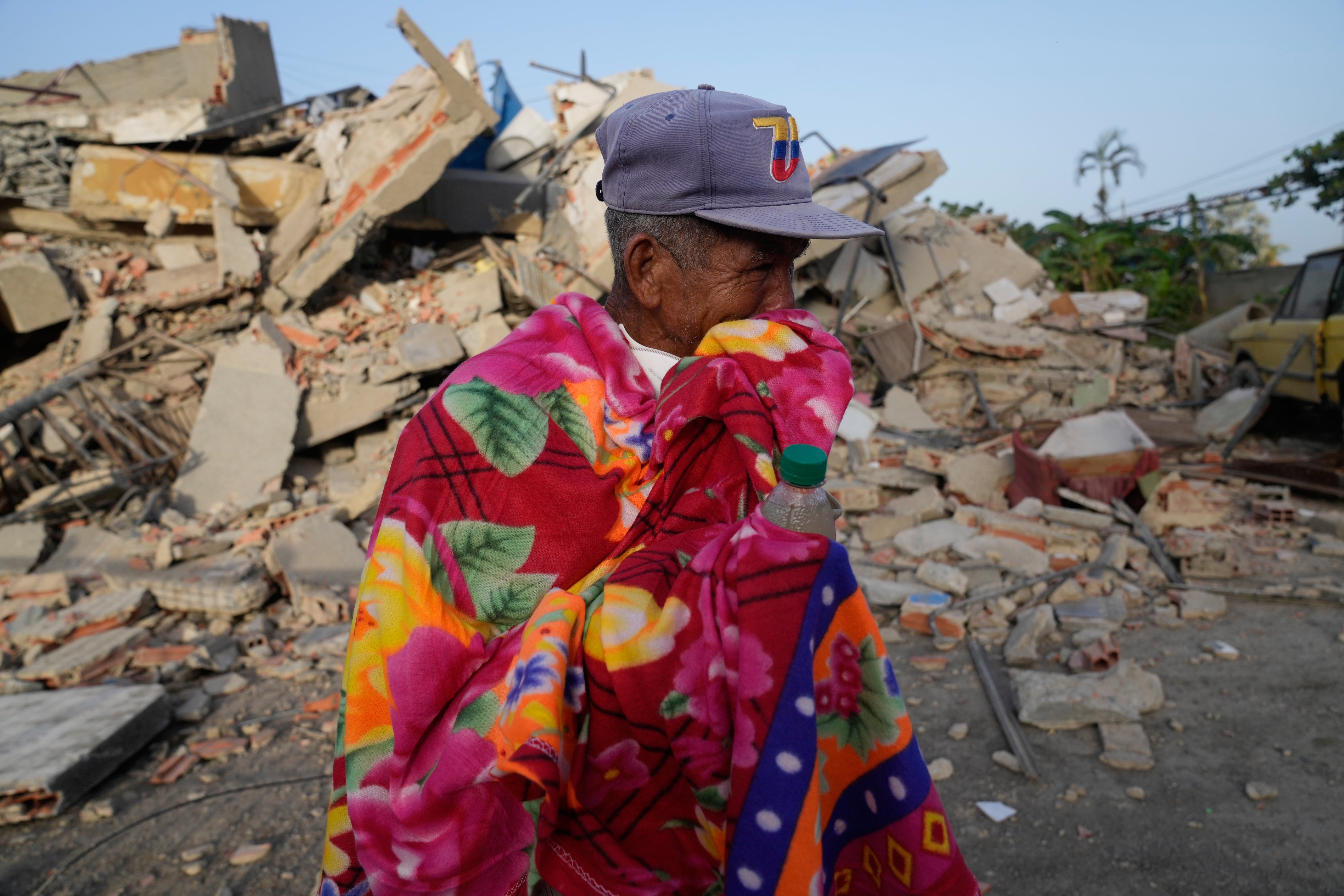 A man stands in front of a collapsed building two days after an earthquake struck La Guaira, Venezuela