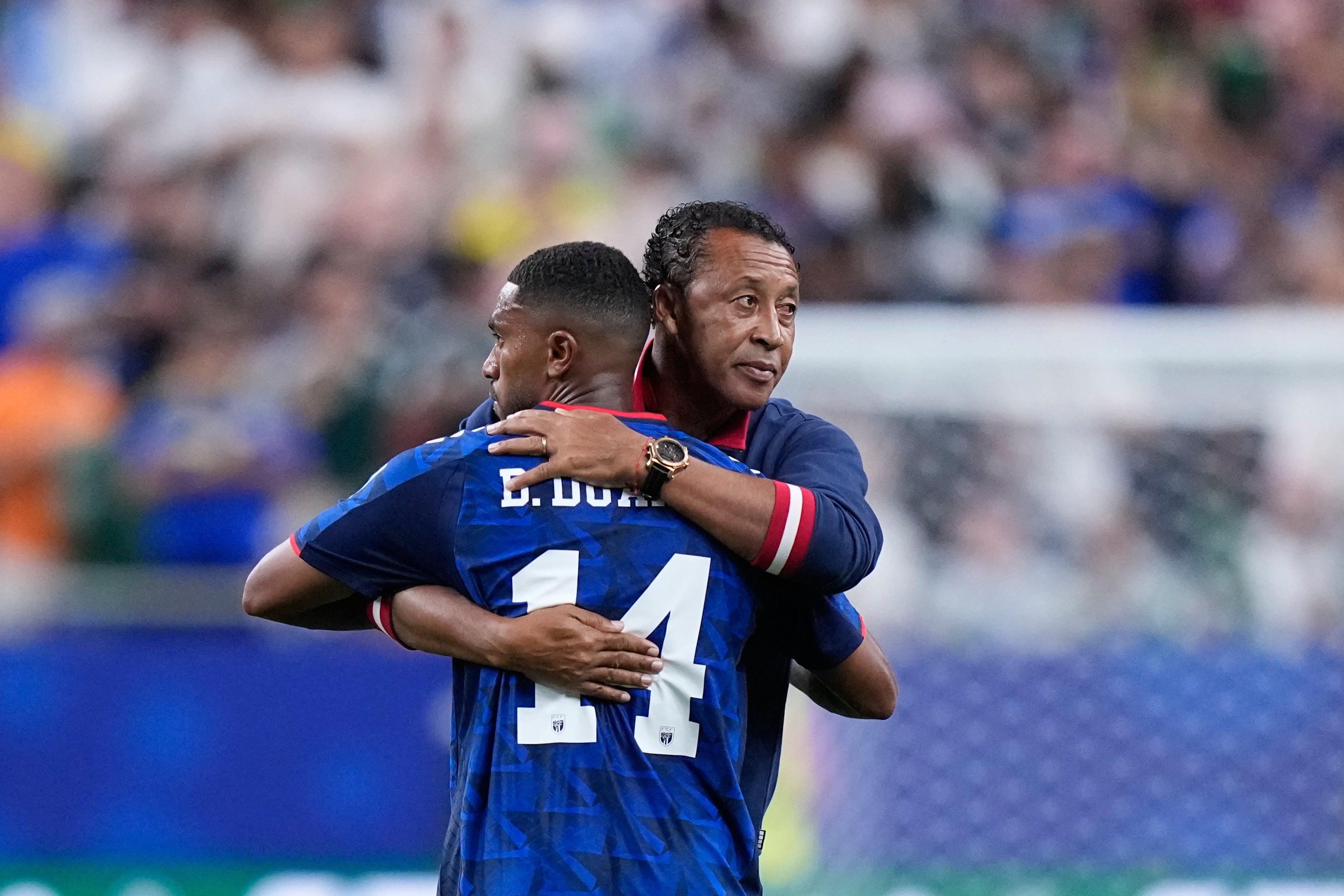 Man of the match Deroy Duarte hugs head coach Bubista (Ashley Landis/AP)
