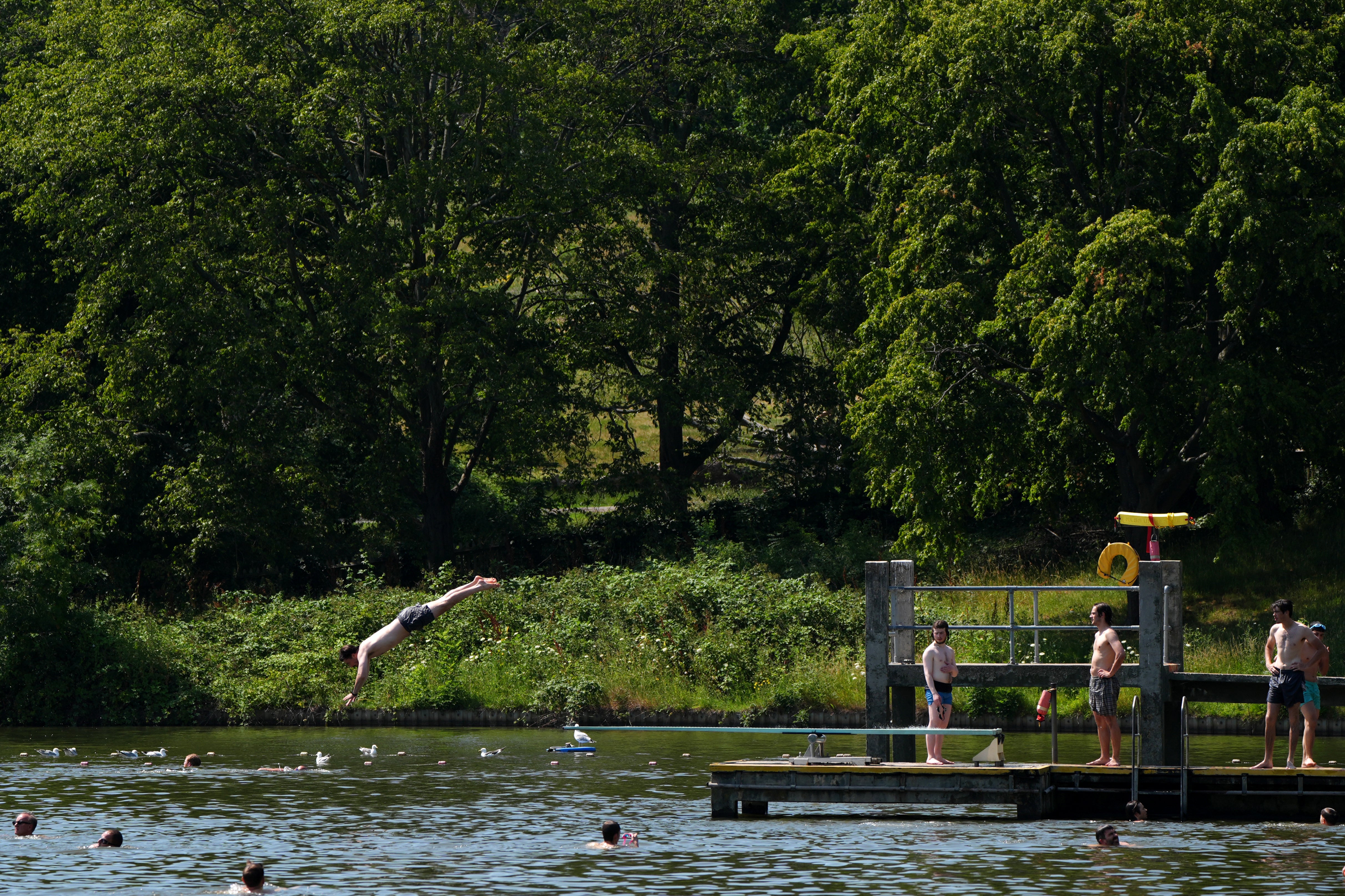 People swim in the swimming pool on Hampstead Heath in London. Meteorology issued a rare red warning against extreme heat