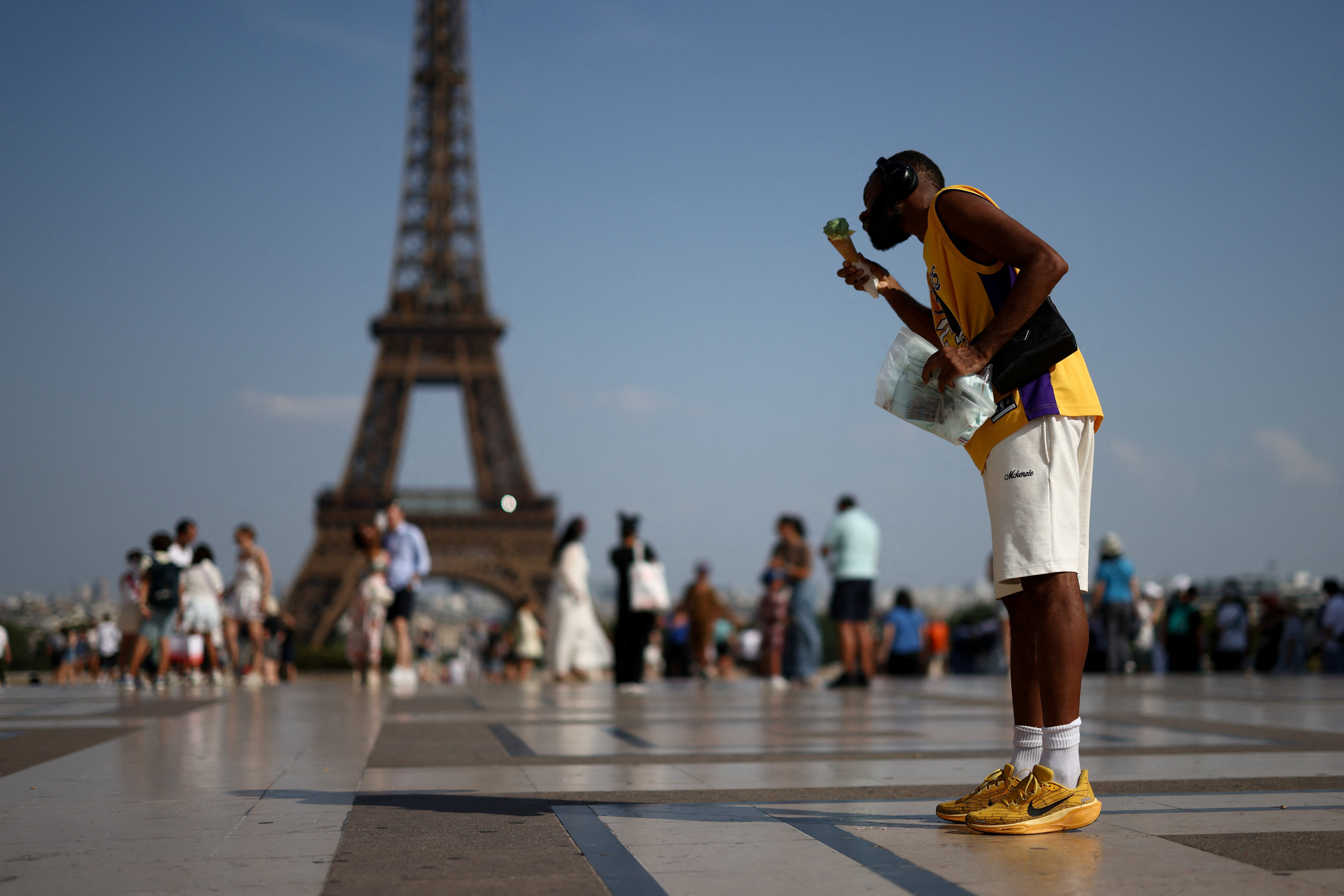 A person eats ice cream in front of the Eiffel Tower during a heatwave in Paris, France, June 27, 2026. REUTERS/Tom Nicholson