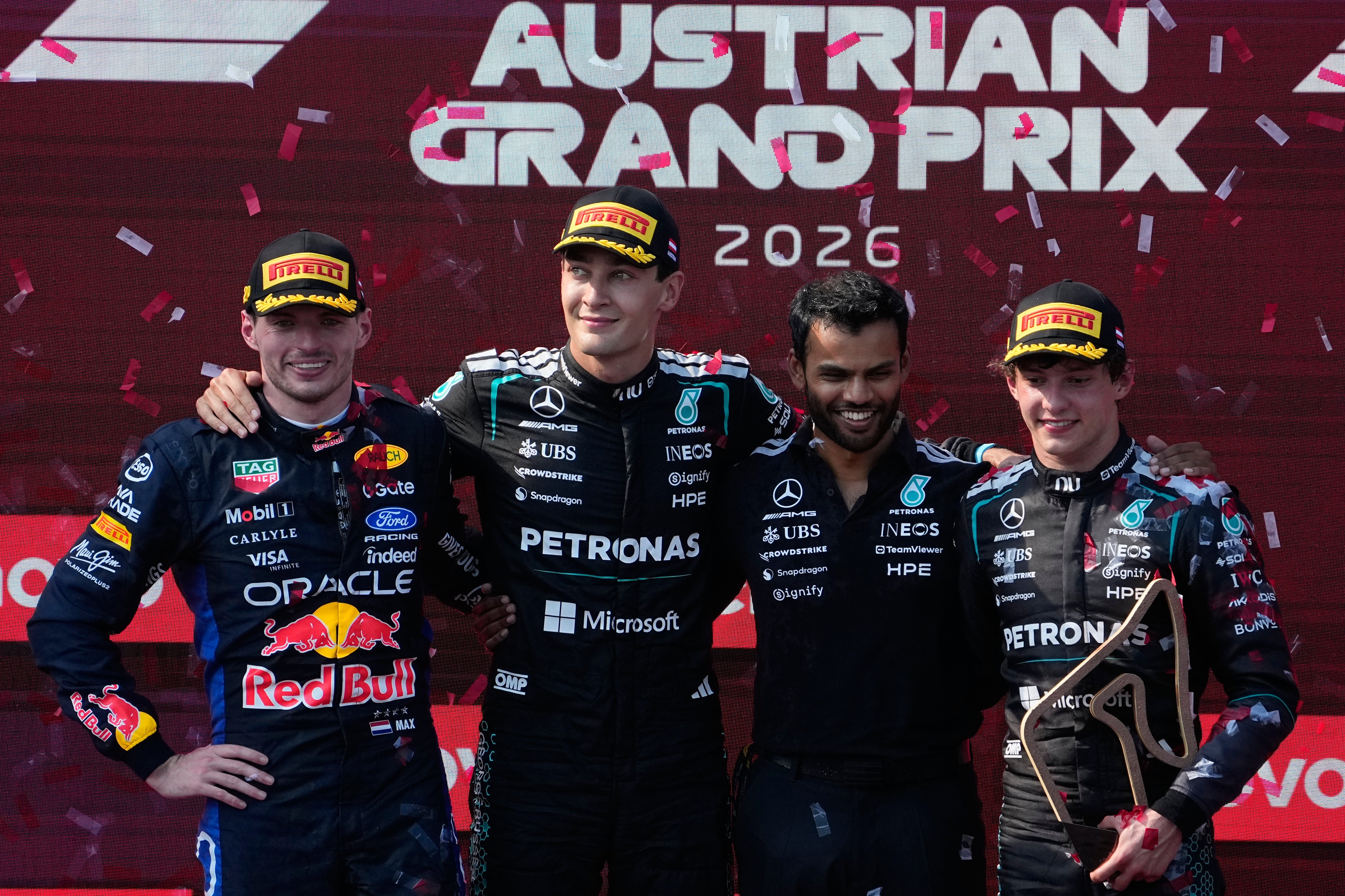 Russell (second left) on the podium with second-placed Max Verstappen (left) and third-placed Kimi Antonelli (right) (Darko Bandic/AP)