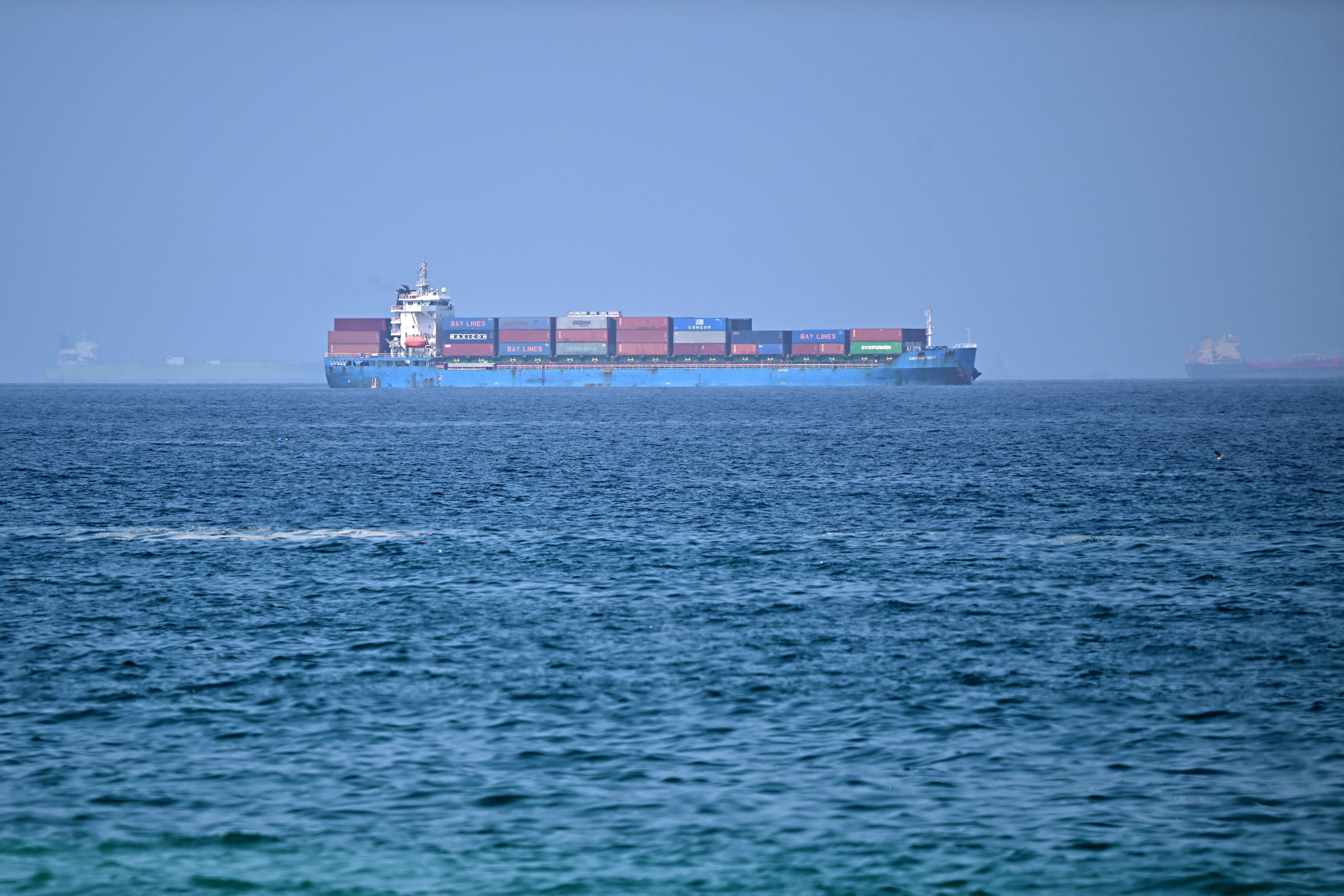 A cargo ship is pictured off coast of the Khor Fakkan Container Terminal, the only natural deep-sea port in the region and one of the major container ports in Sharjah Emirate, along the Gulf of Oman on 28 June 2026