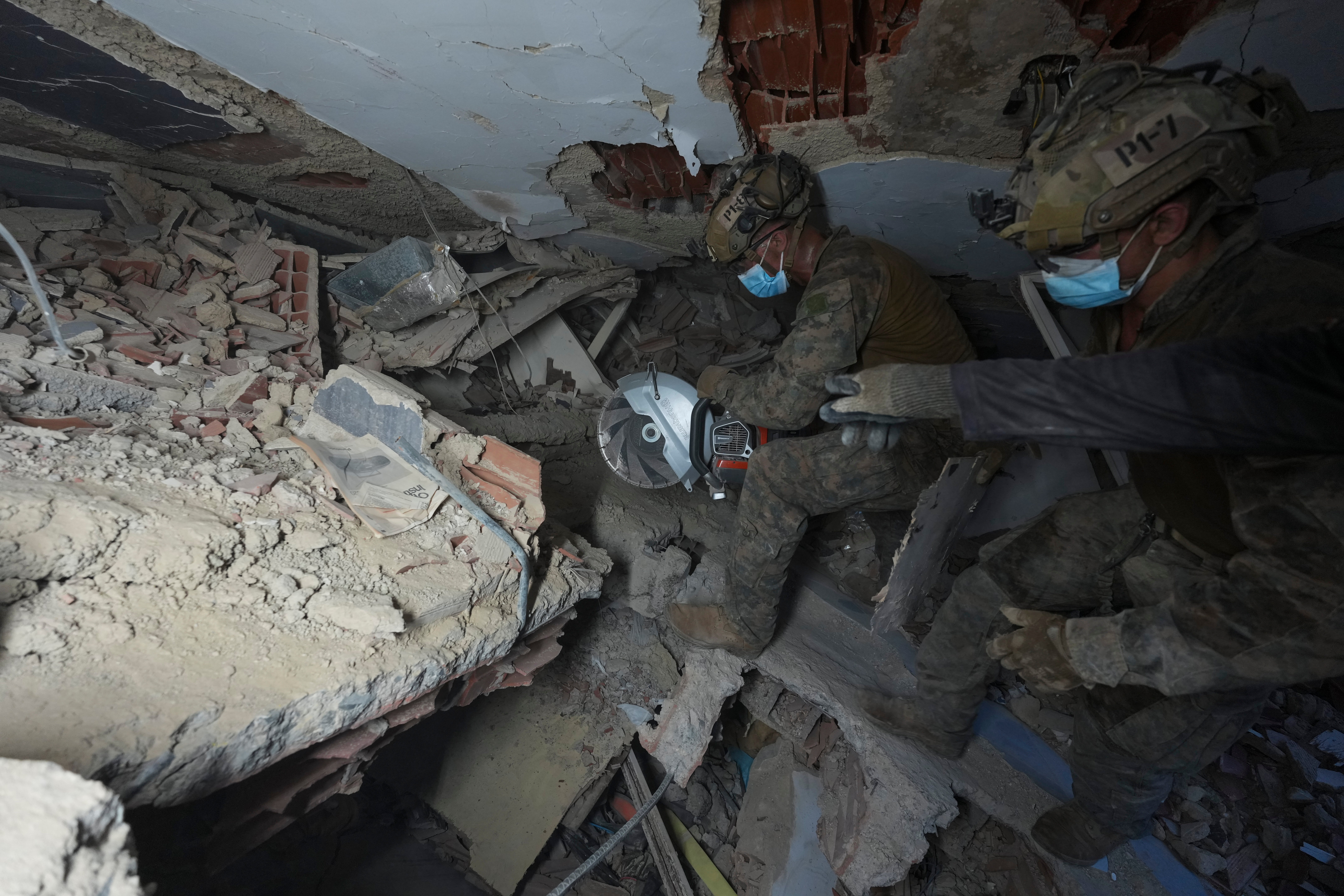 Rescuers make their way through the rubble in search of earthquake survivors in La Guaira, Venezuela (AP)