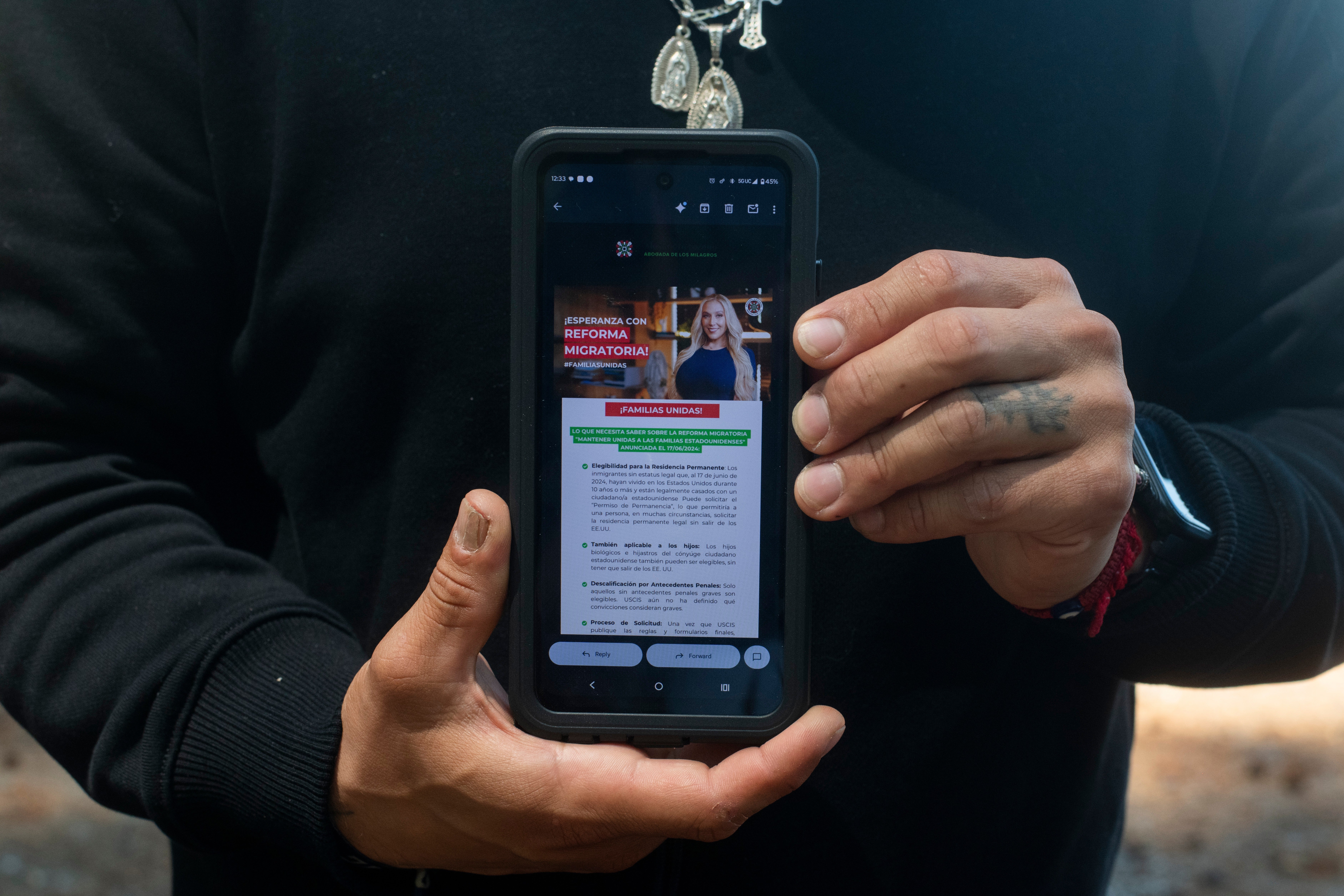 Garcia poses with an email advertisement from attorney Lozano displayed on his phone