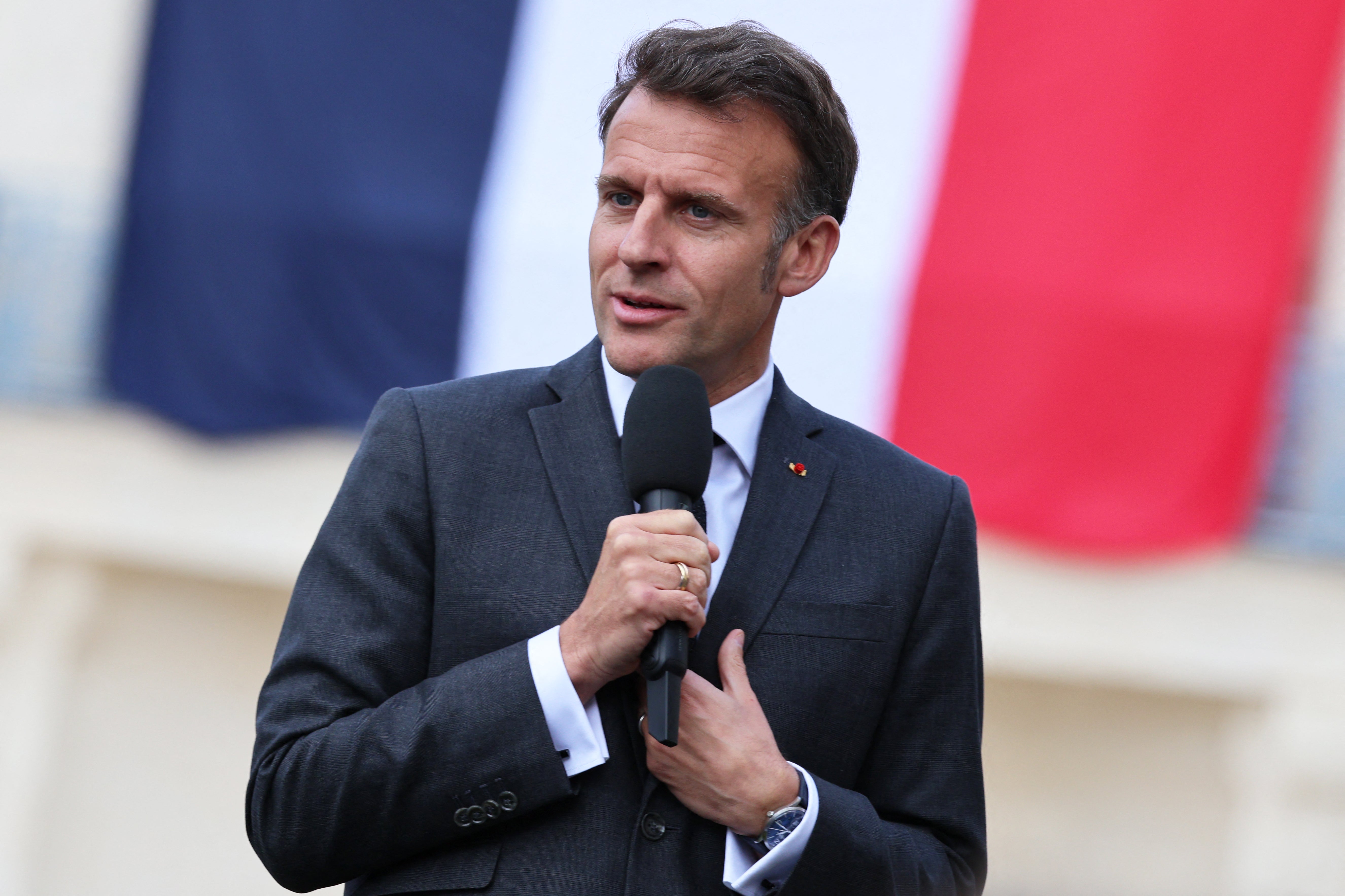 France's President Emmanuel Macron delivers a speech with a French flag in the background during his visit to the International City of French Language (Cite Internationale de la Langue Francaise) to promote 'disconnecting' and 'reading' as alternatives to screens as part of his fight to ban social networks for the youngest