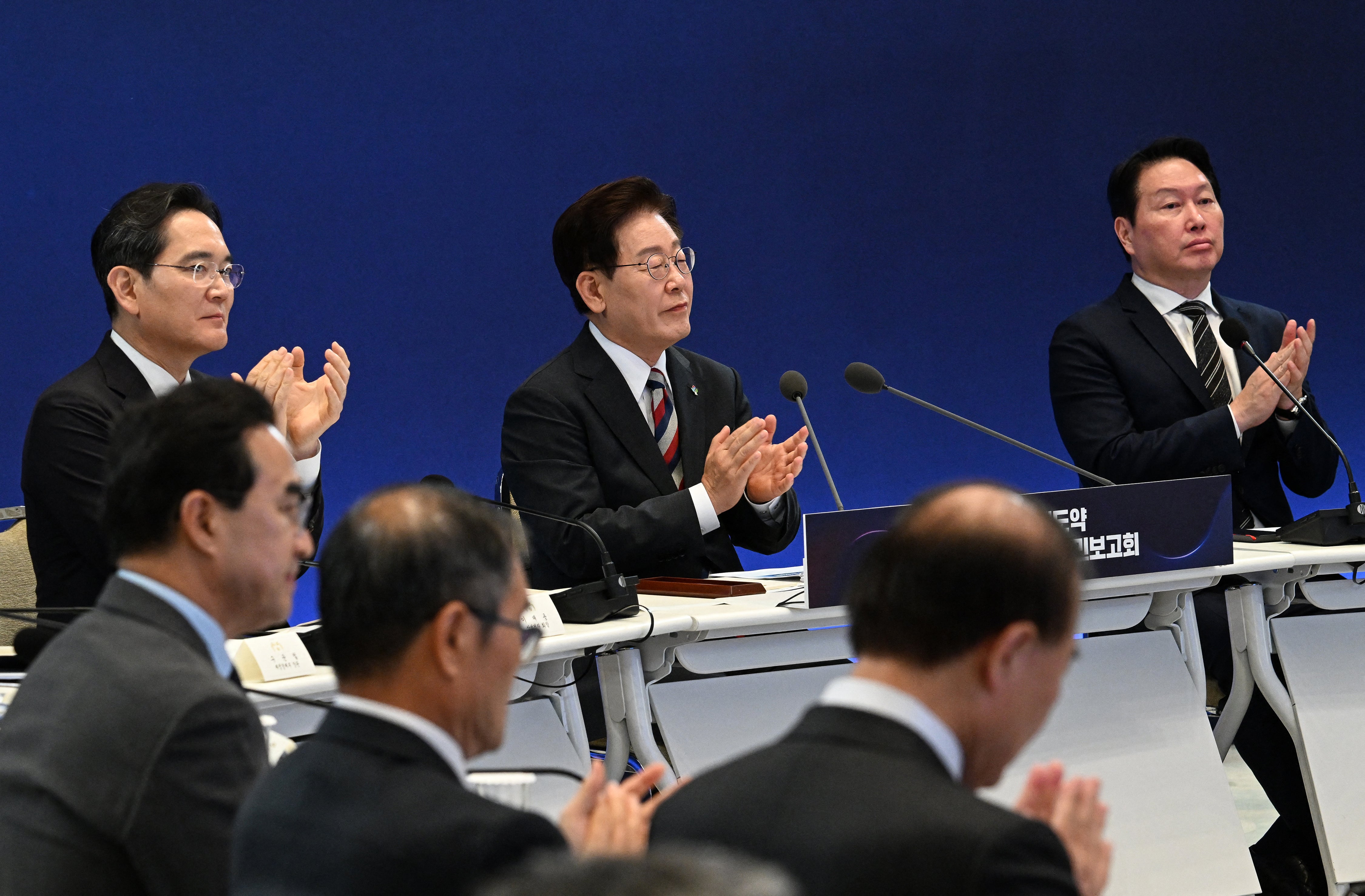 South Korean President Lee Jae Myung (C), Samsung Electronics Chairman Lee Jae-yong (L) and SK Group Chairman Chey Tae-won (R) attend the briefing announcement of public-private collaboration projects at the presidential Blue House in Seoul (POOL/AFP via Getty Images)
