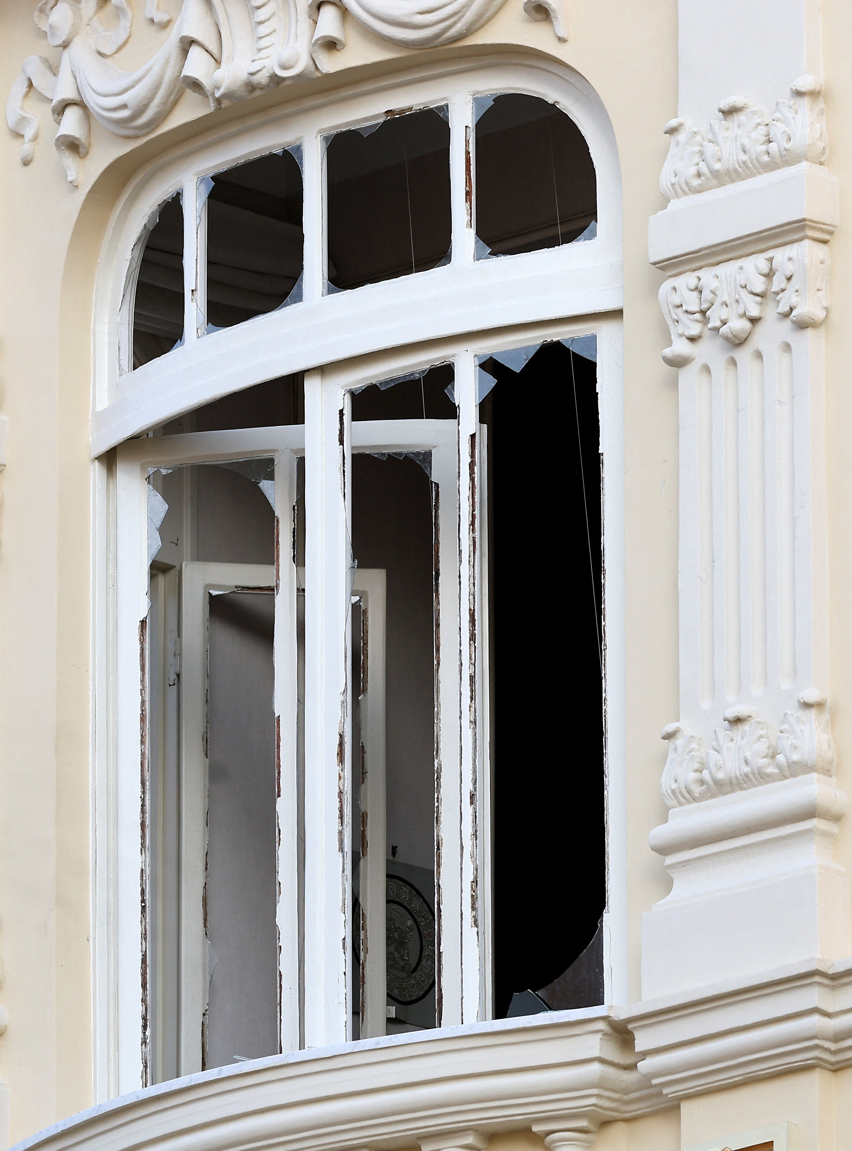 Shards of glass on a damaged window of a residential building, following an explosion on Monday