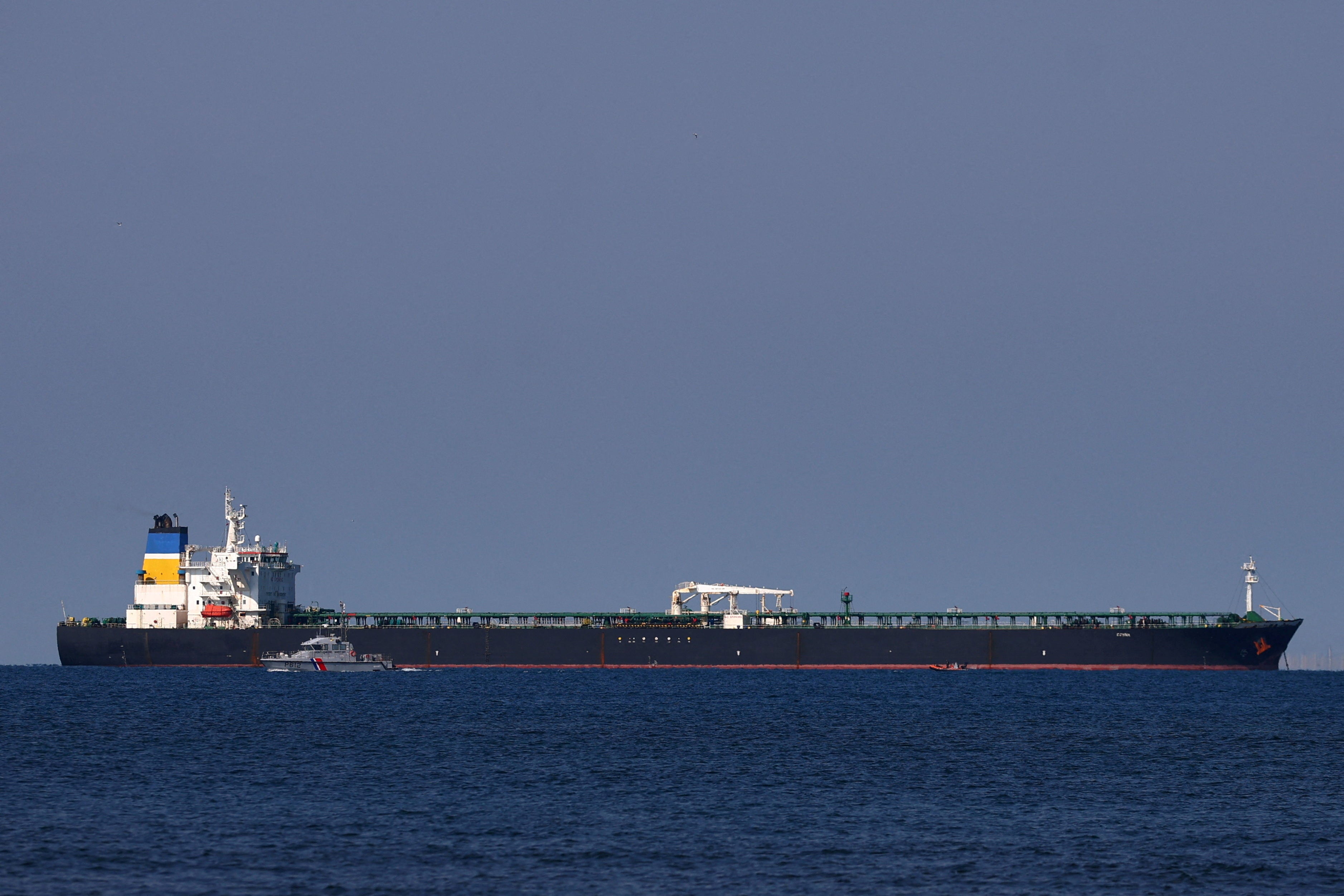 A French Maritime Gendarmerie boat patrols around the Mozambique-flagged oil tanker named Deyna, which France says is part of Russia's shadow fleet.