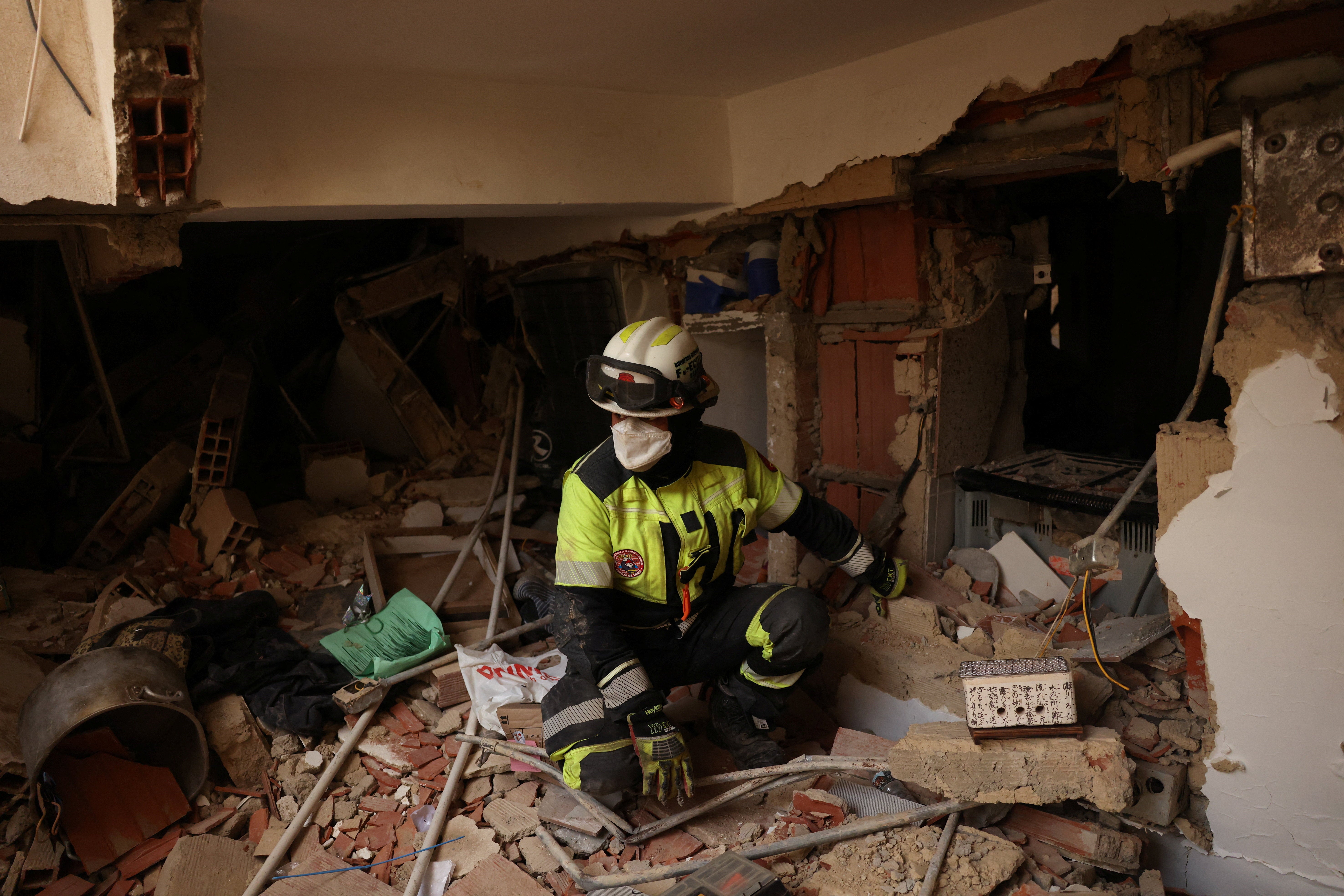 A member of the ECU-11 Guayaquil Fire Department from Ecuador takes part in rescue efforts inside a building that collapsed in La Guaira