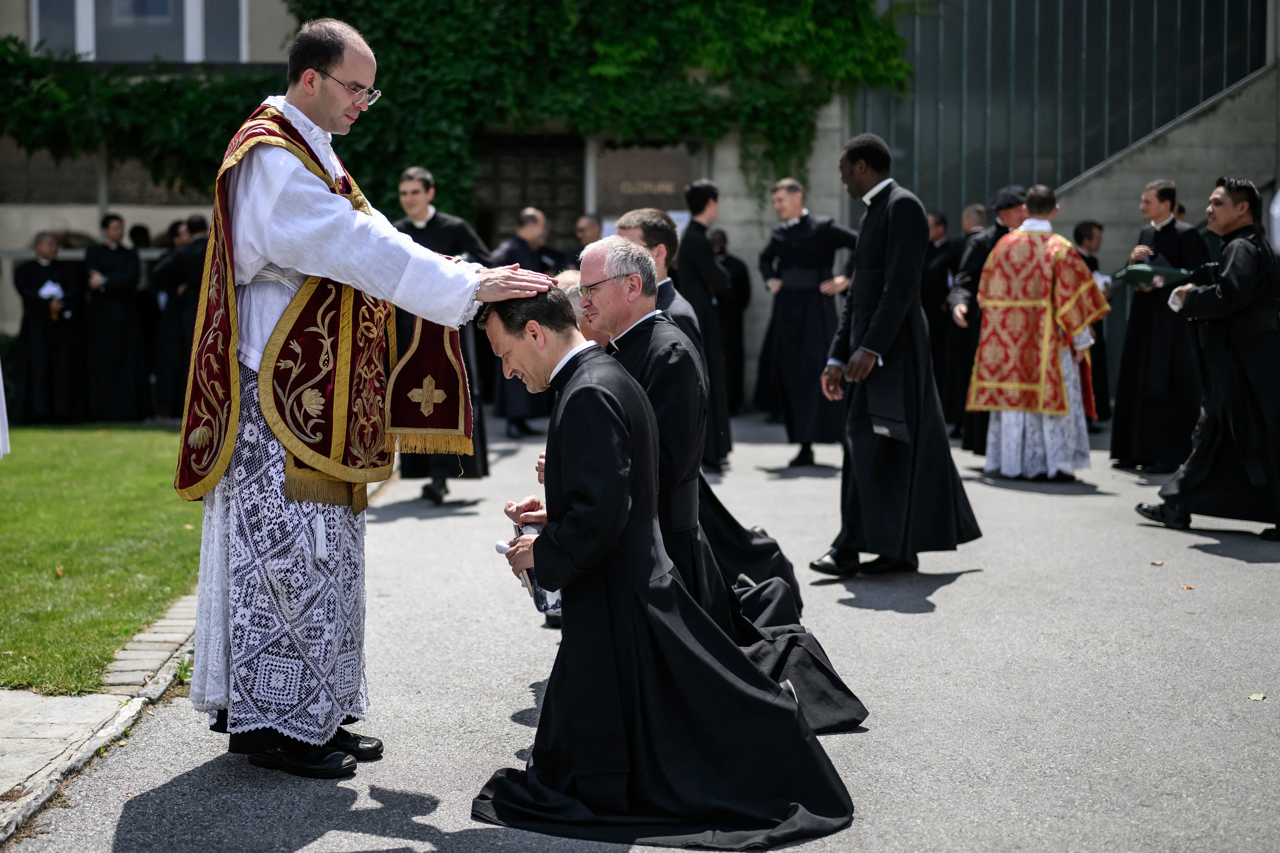 Newly ordained priest Spain's Carlos Hernanz Gallego gives blessings to priests, after an ordination ceremony of the traditionalist Catholic Society of Saint Pius X (SSPX).