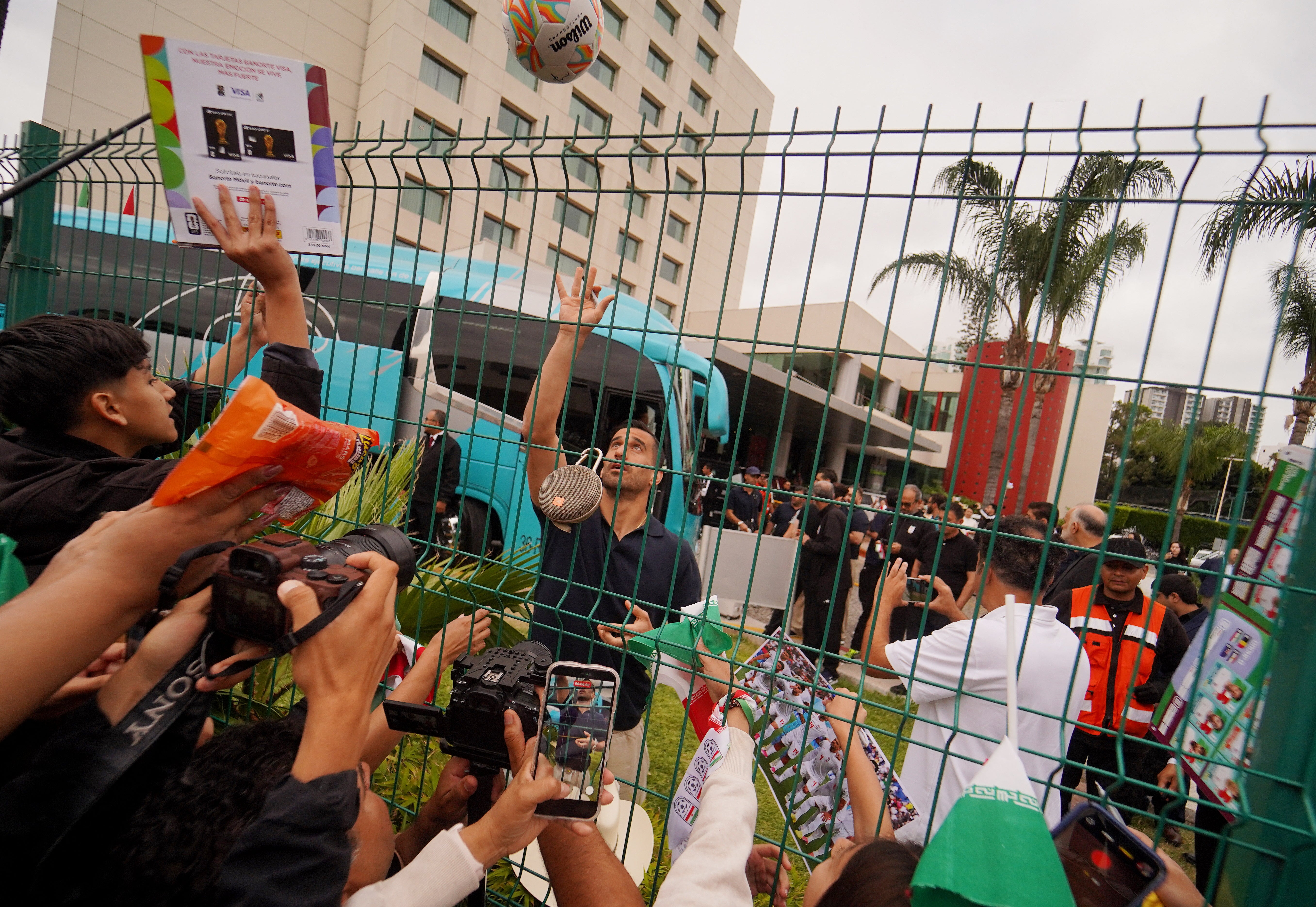 Iran's Ehsan Hajsafi reacts with fans outside the team hotel (Reuters)