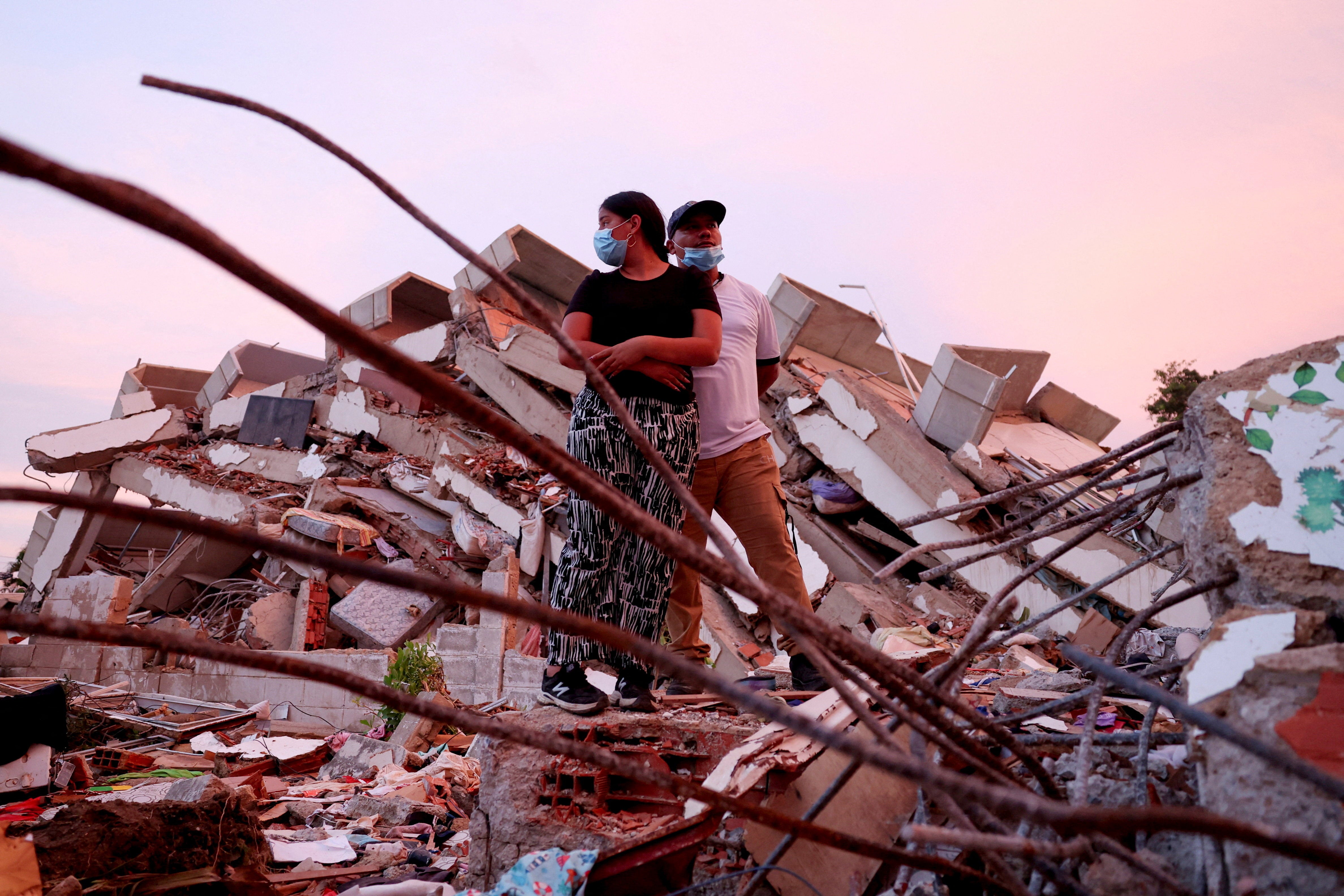 Yohancy Gil, 24, and her husband Sergio Guanipa, 30, wait for news from rescue teams looking for their children under the rubble of a collapsed building in La Guaira