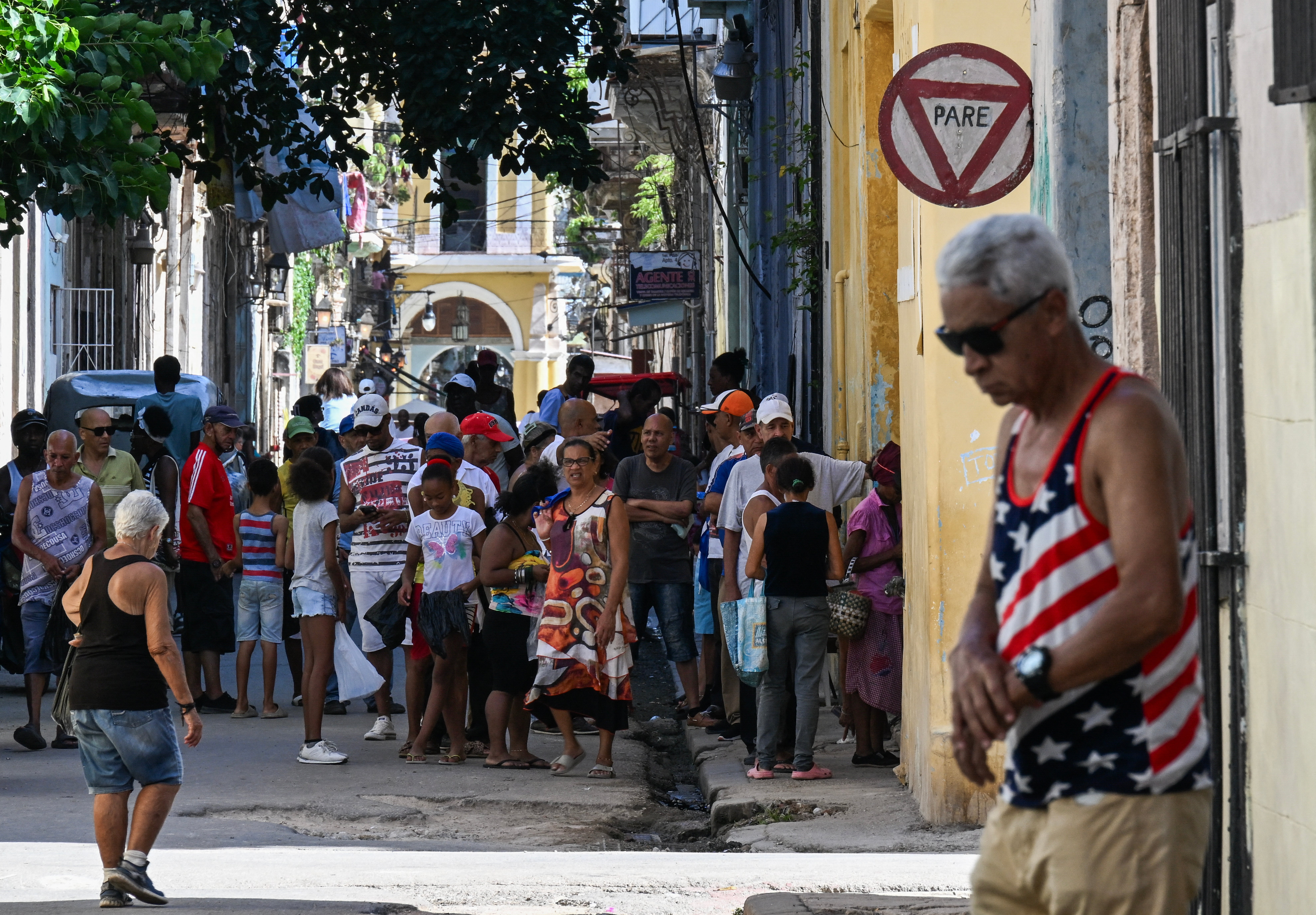 A man wearing a T-shirt featuring the US flag walks down a street in Havana on 30 June