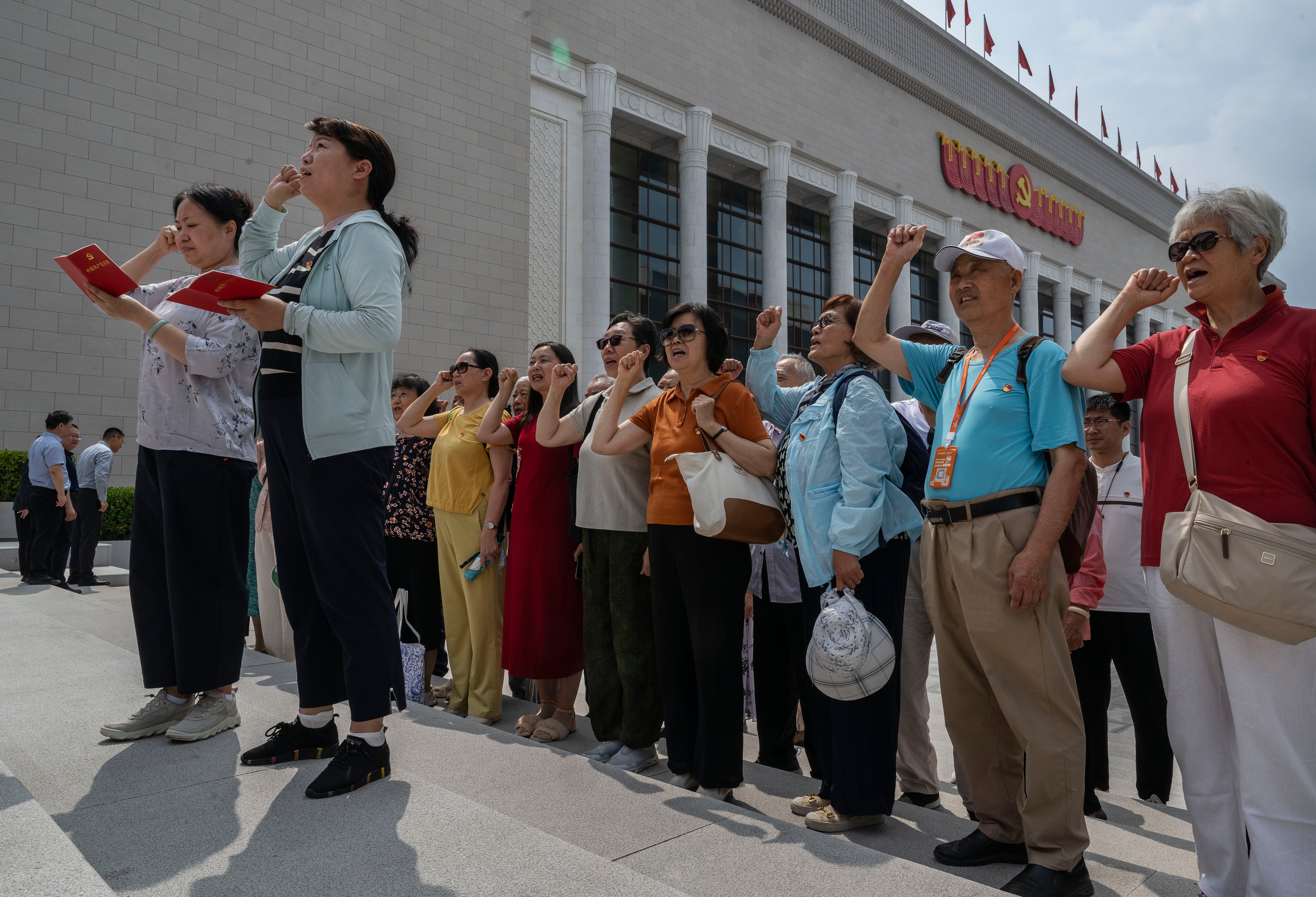 People say an oath of loyalty in front of a flag of the Communist Party of China on the 105th anniversary of its founding in Beijing on 1 July 2026