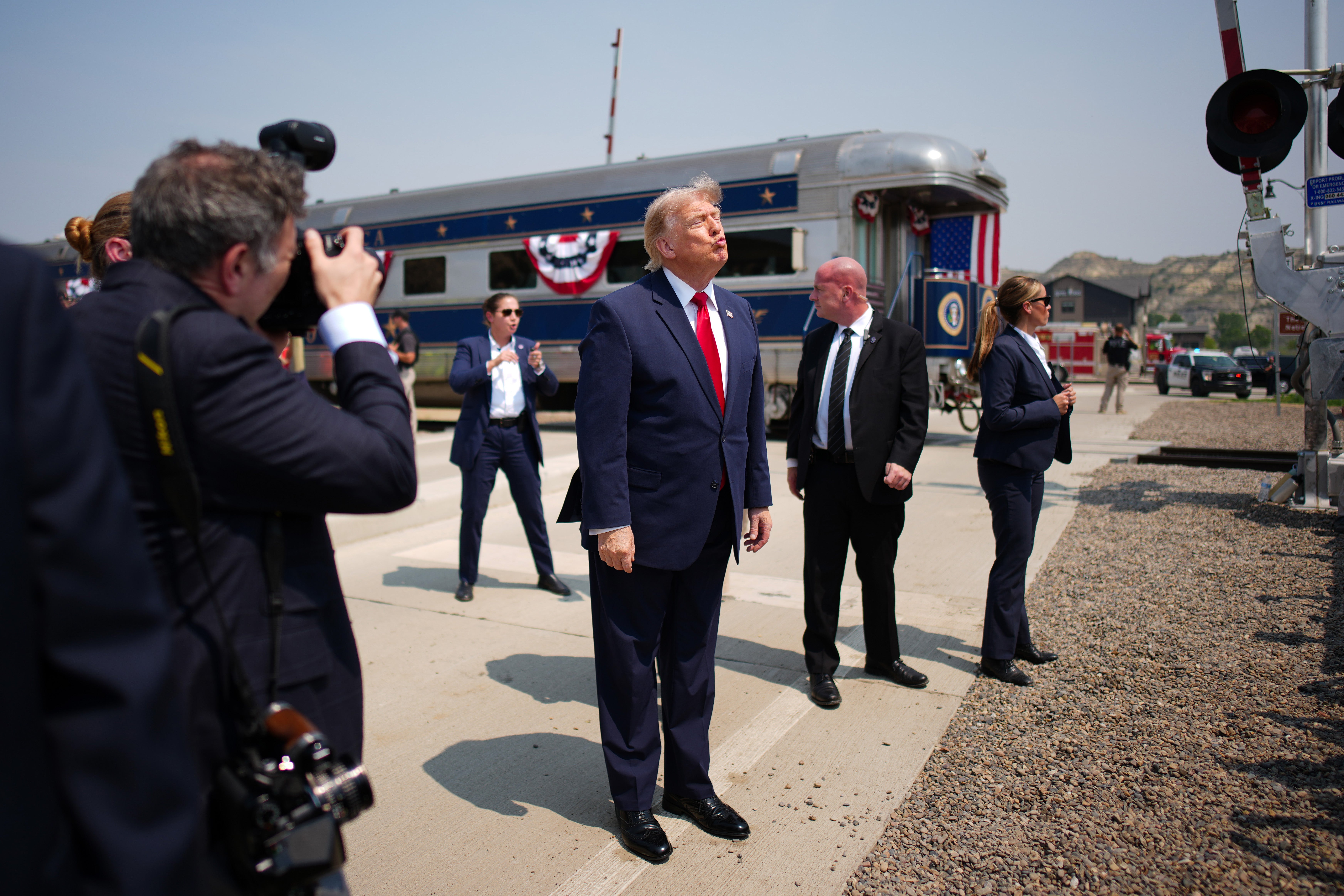 The president is flanked by security and photographers next to the train (Getty Images)