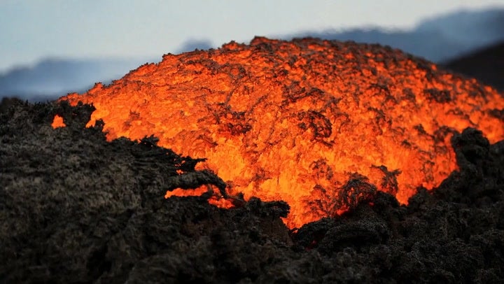 Orange lava flows stream from Mount Etna