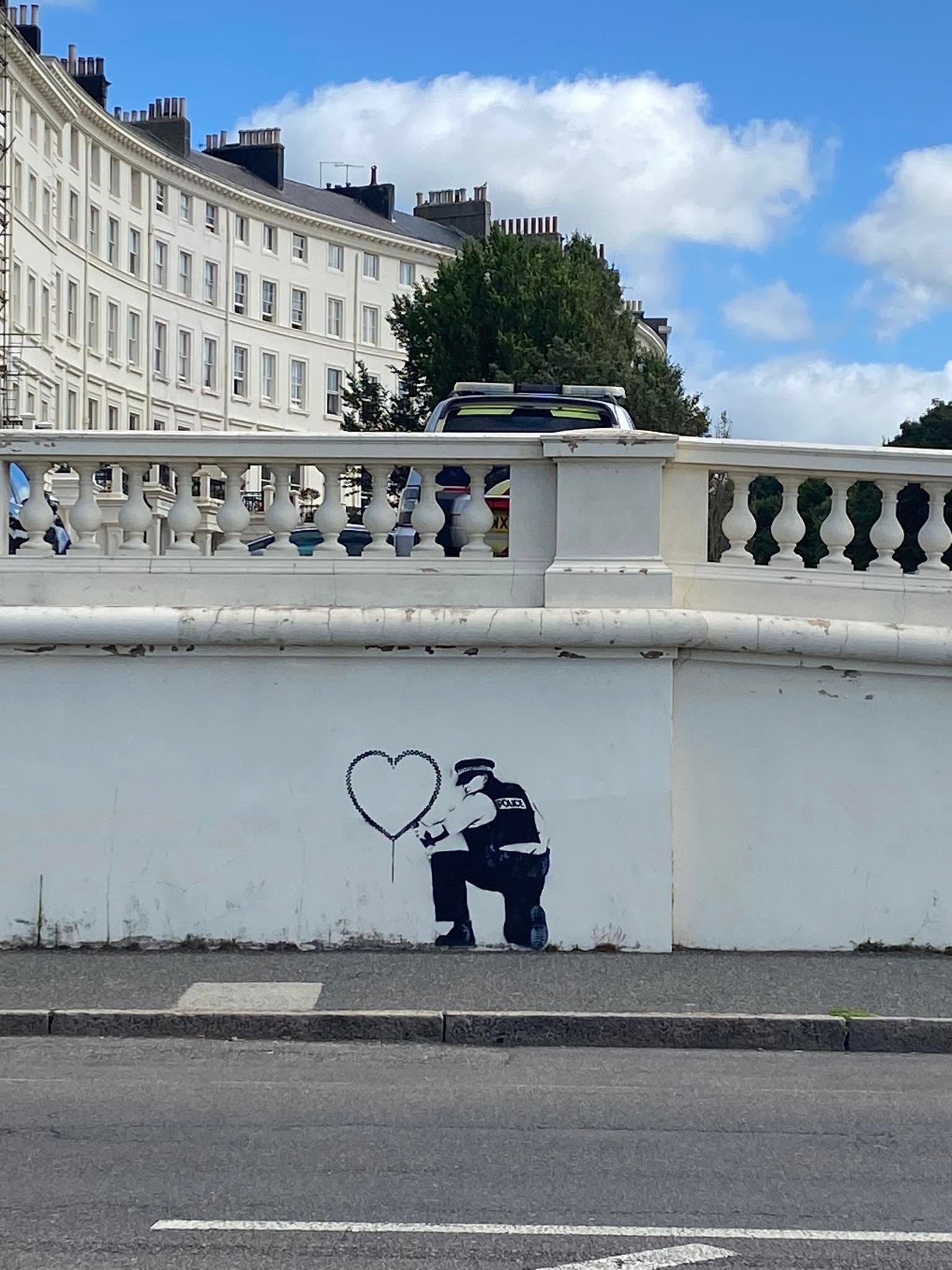 A police car can be seen near an alleged Banksy mural on Hove beach on Wednesday