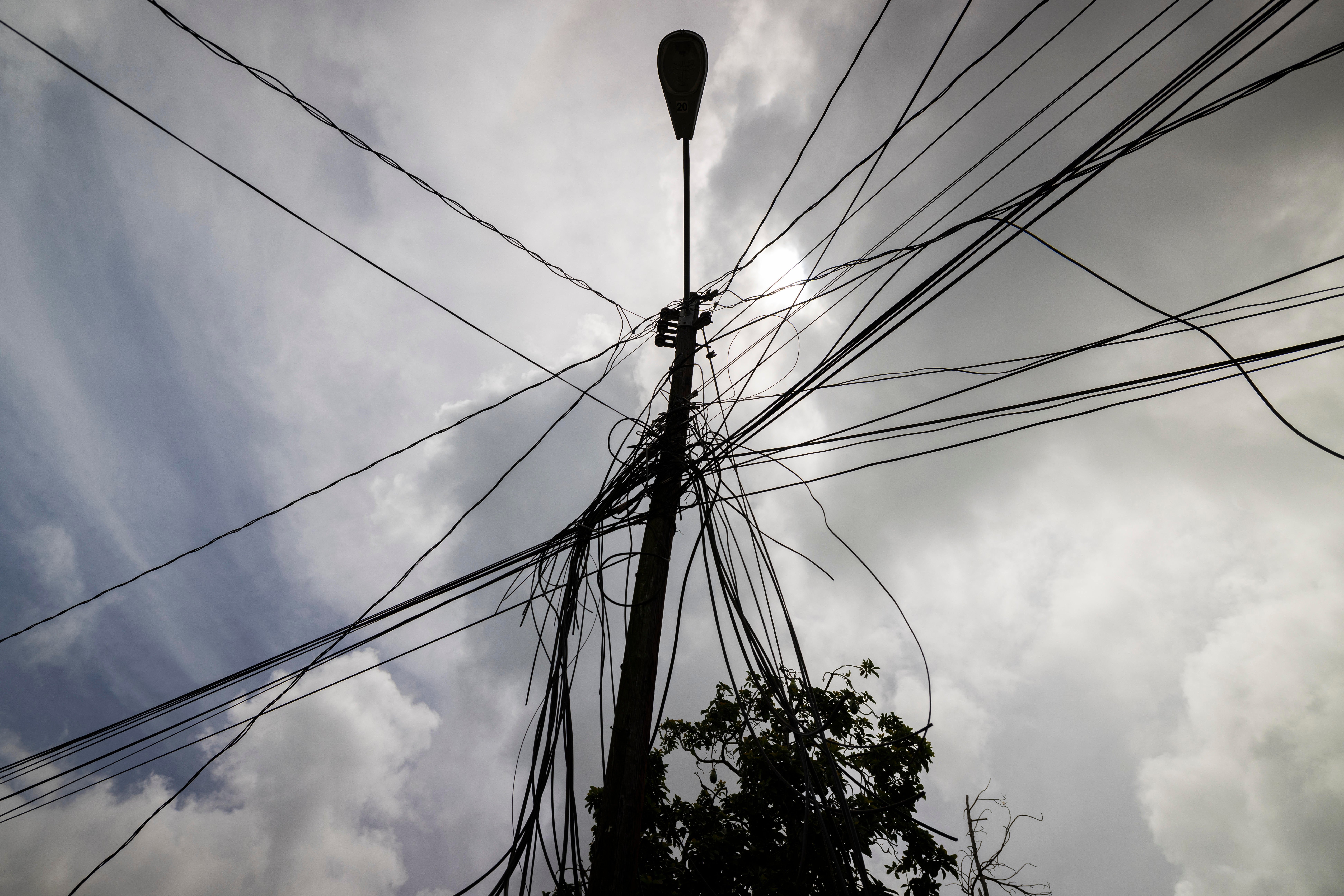 A utility pole with loose cables towers over the home of Jetsabel Osorio in Loiza, Puerto Rico (Copyright 2021 The Associated Press. All rights reserved)