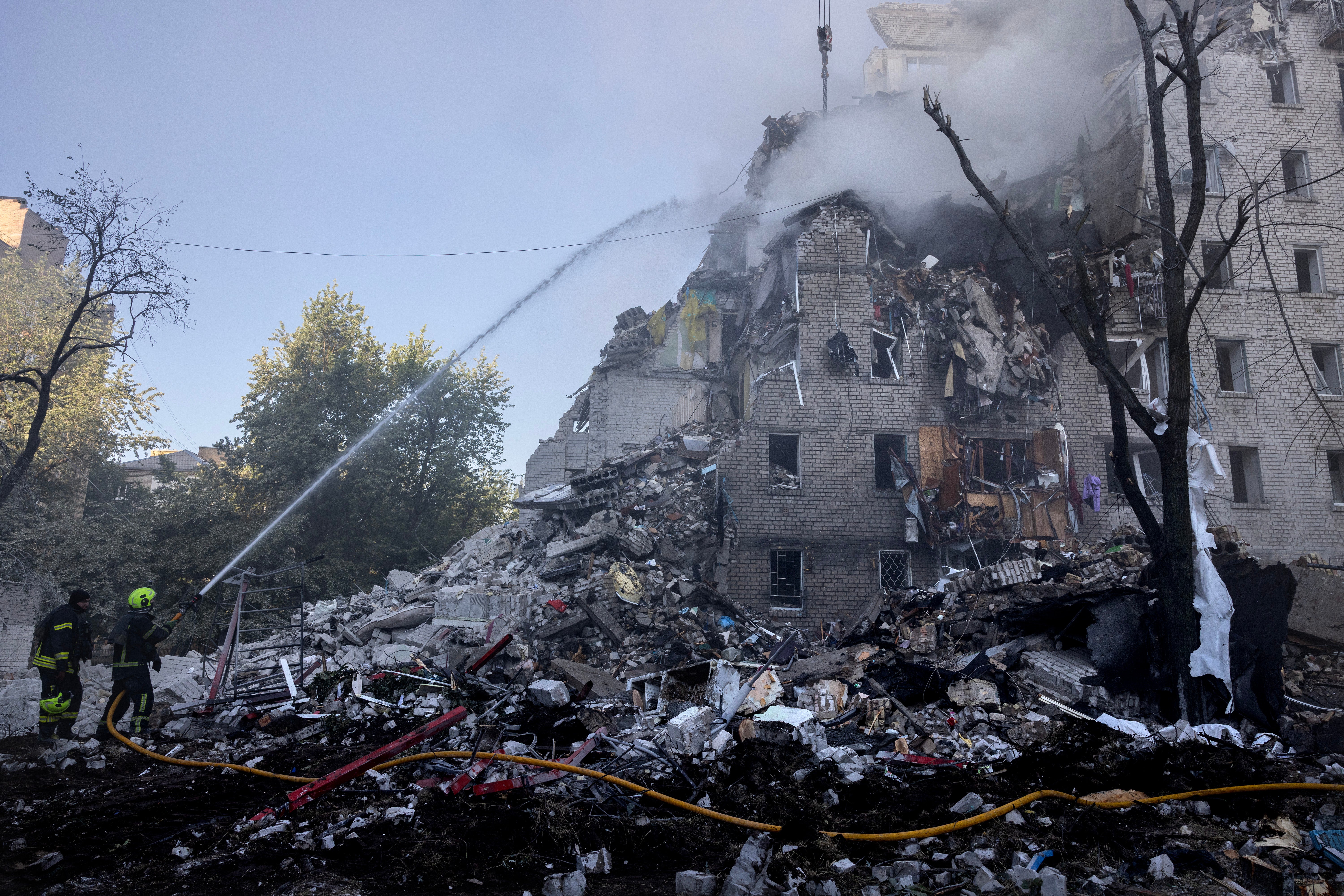 Firefighters work at a building that collapsed as major fires burn at multiple locations after a drone and missile attack by Russian forces (Getty)