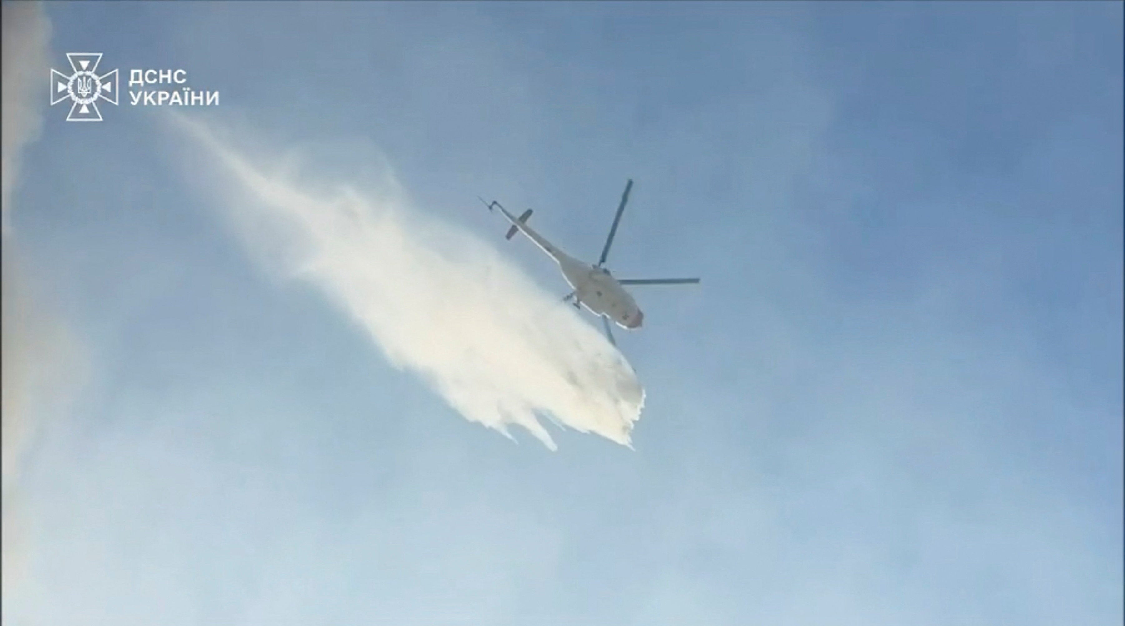 A helicopter releases water while attempting to put out fires in Kyiv (Reuters)