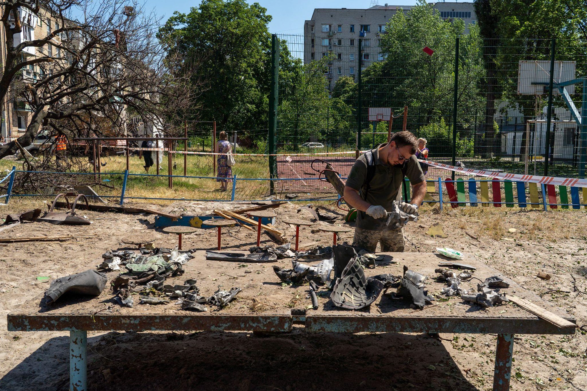 A Ukrainian serviceman inspects the remnants of a Russian missile in Darnytsia