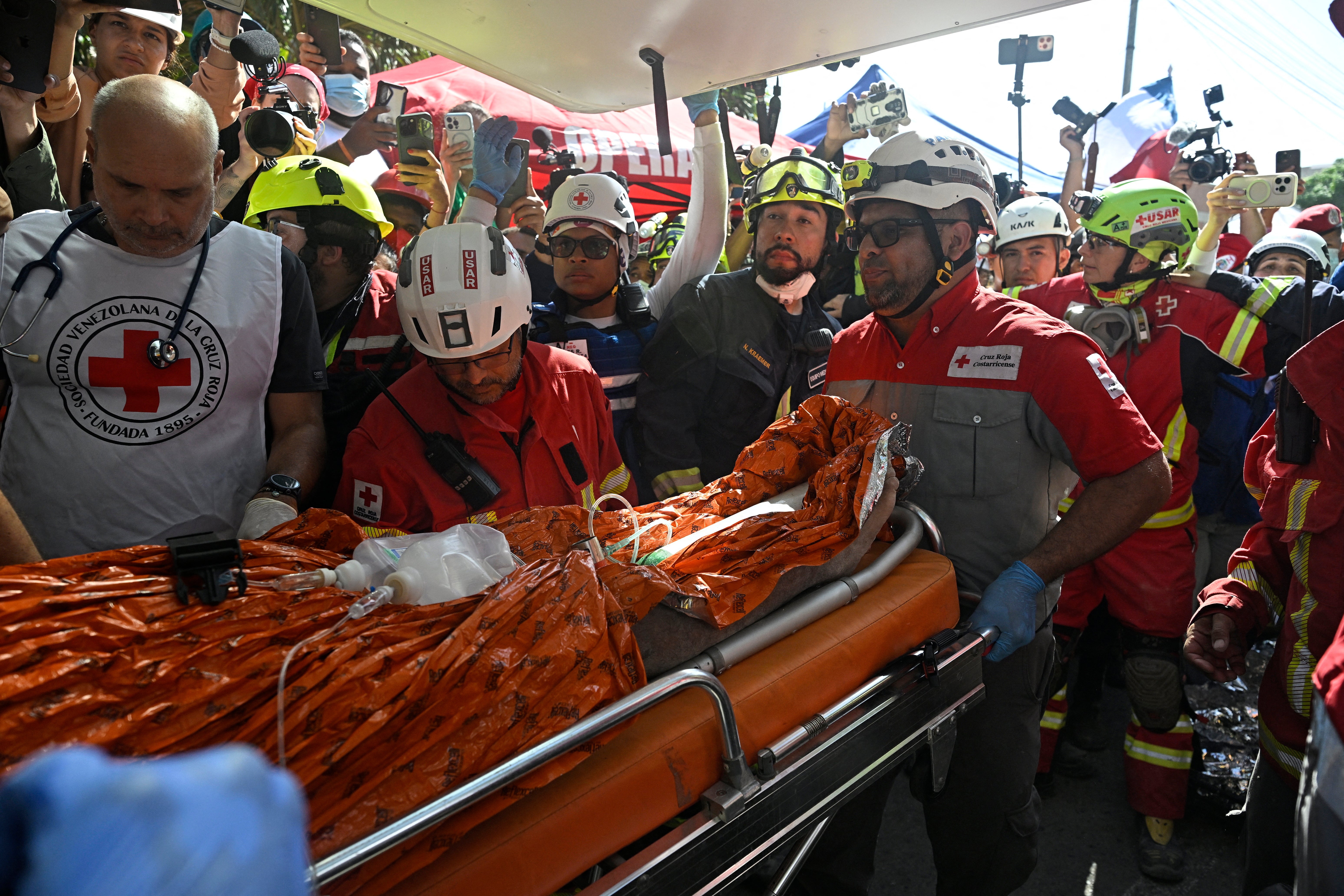 An international rescue team loads Hernan Gil, a survivor of Venezuela's twin earthquakes, into an ambulance in Catia La Mar, La Guaira State, Venezuela on July 2, 2026, eight days after the quake