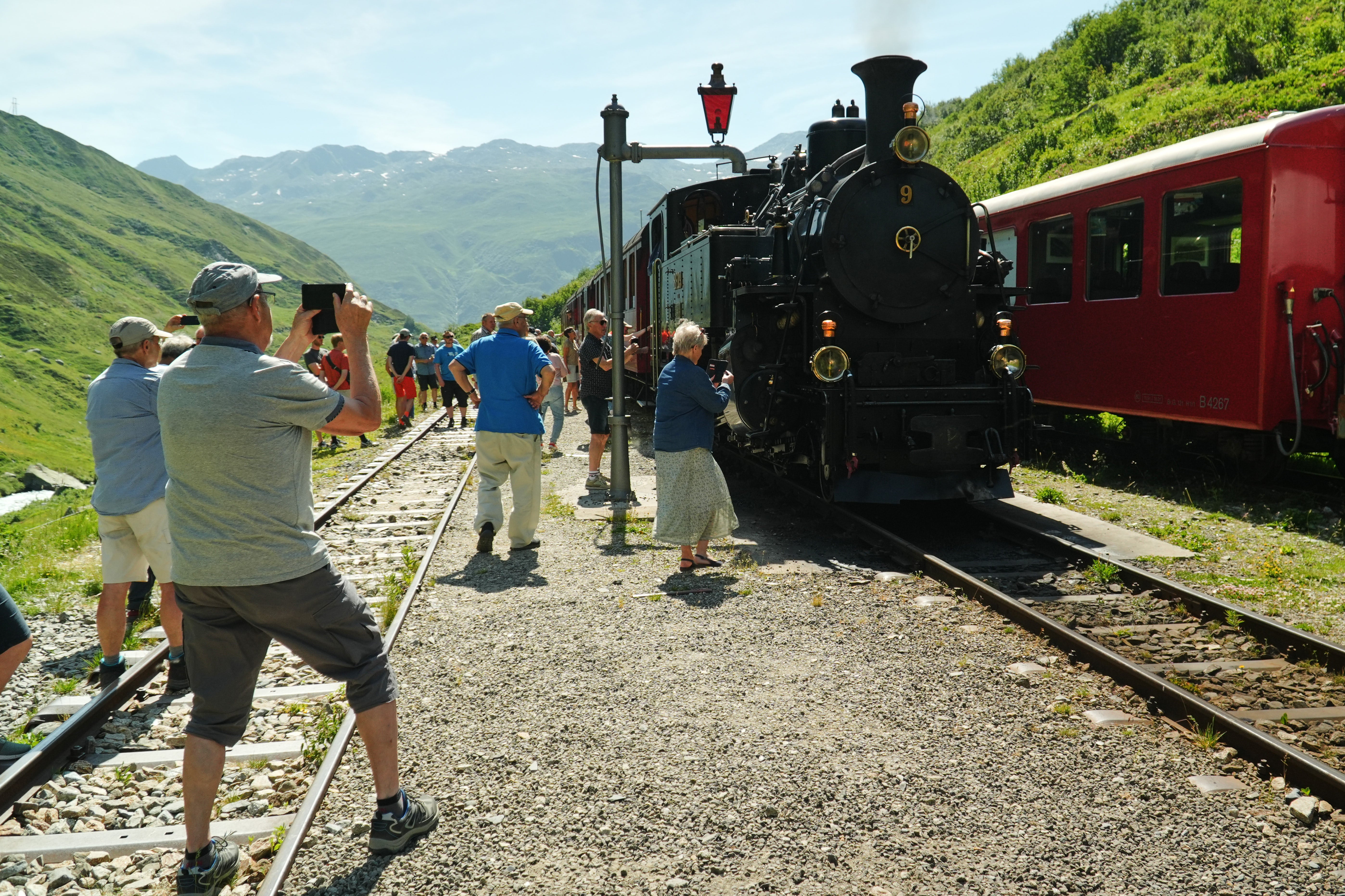 Passengers take photos during a train stop to refill the locomotive with water at Tiefenbach station.