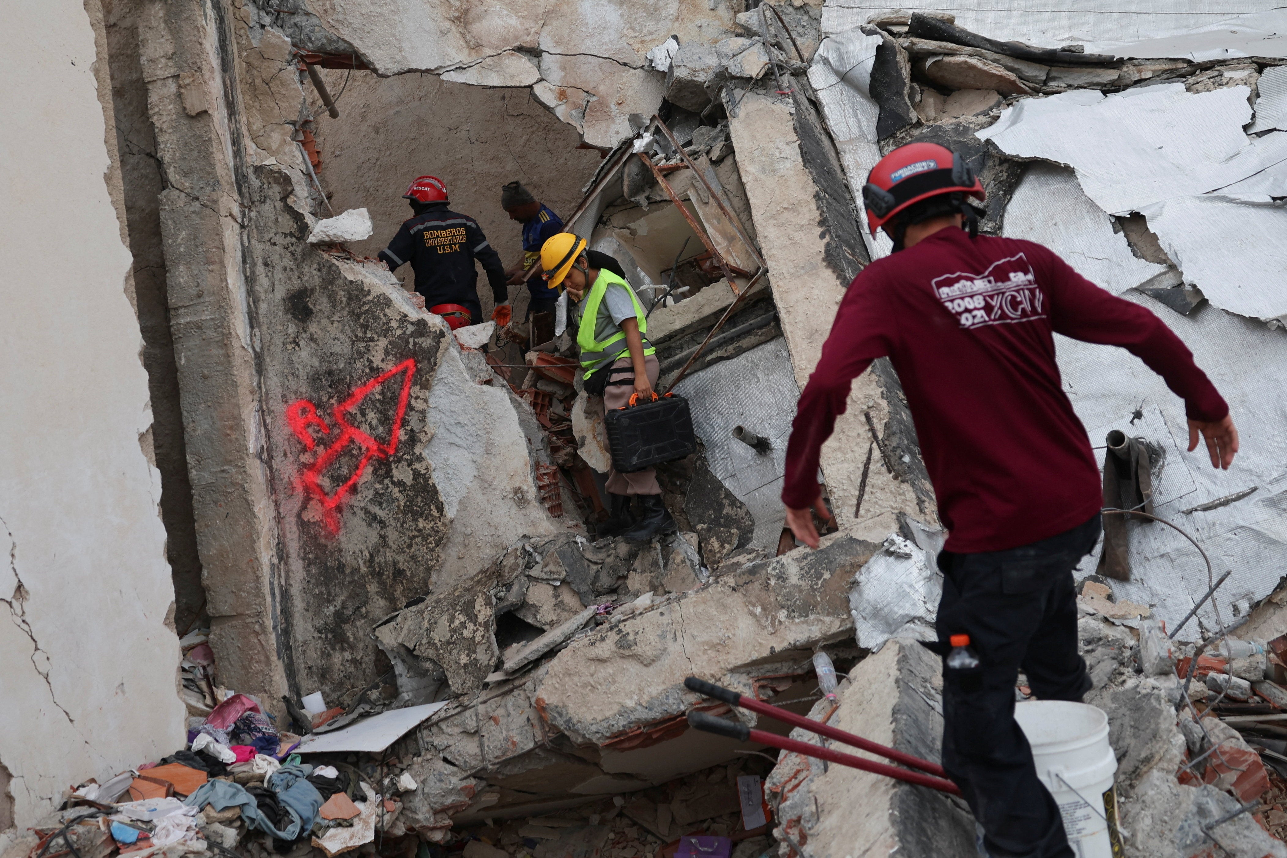 Rescuers work at the site of a collapsed building, in the aftermath of earthquakes, in La Guaira (Reuters)
