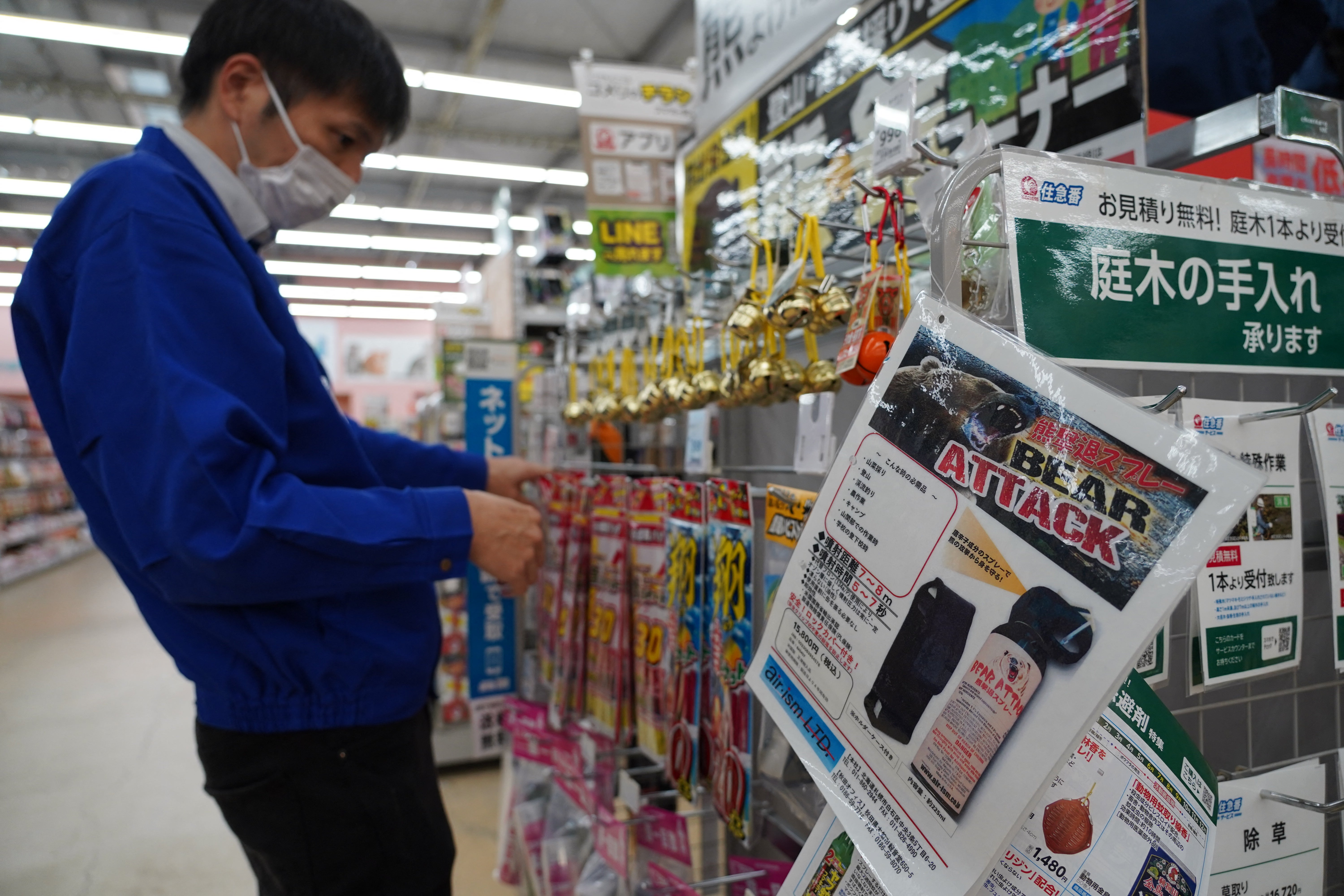 A staff member sorts bells next to an advertisement for bear spray at a store in Hanamaki (AFP/Getty)