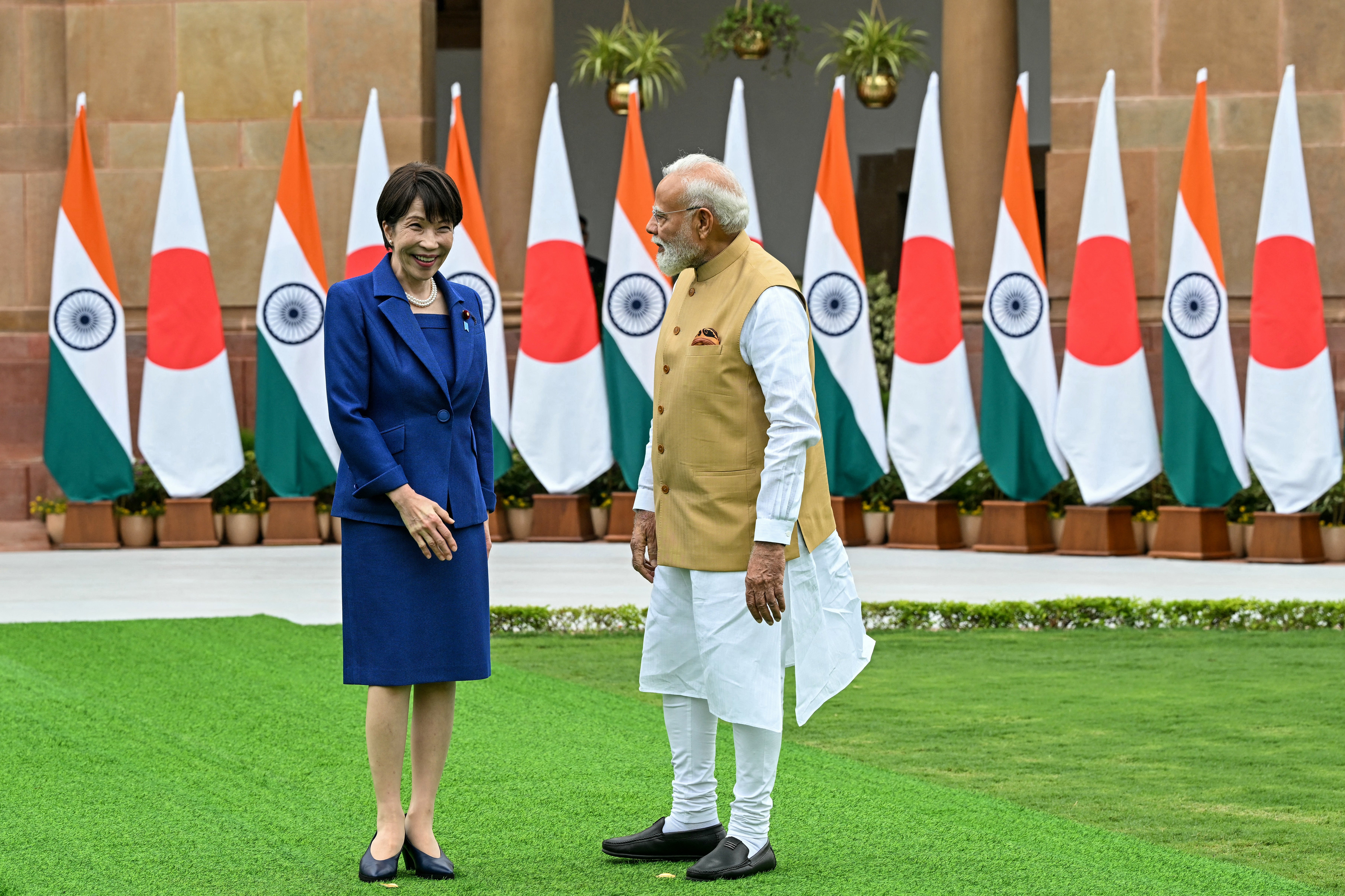 India's Prime Minister Narendra Modi (R) looks on as Japan's Prime Minister Sanae Takaichi reacts before their meeting at the Hyderabad House