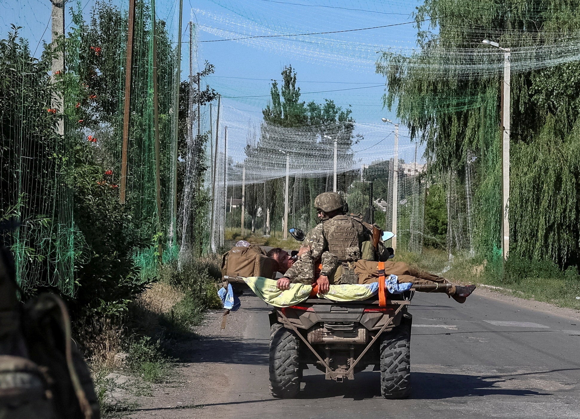 Ukrainian servicemen evacuate their wounded colleague, amid Russia's attack on Ukraine, at a frontline in Donetsk region (Reuters)