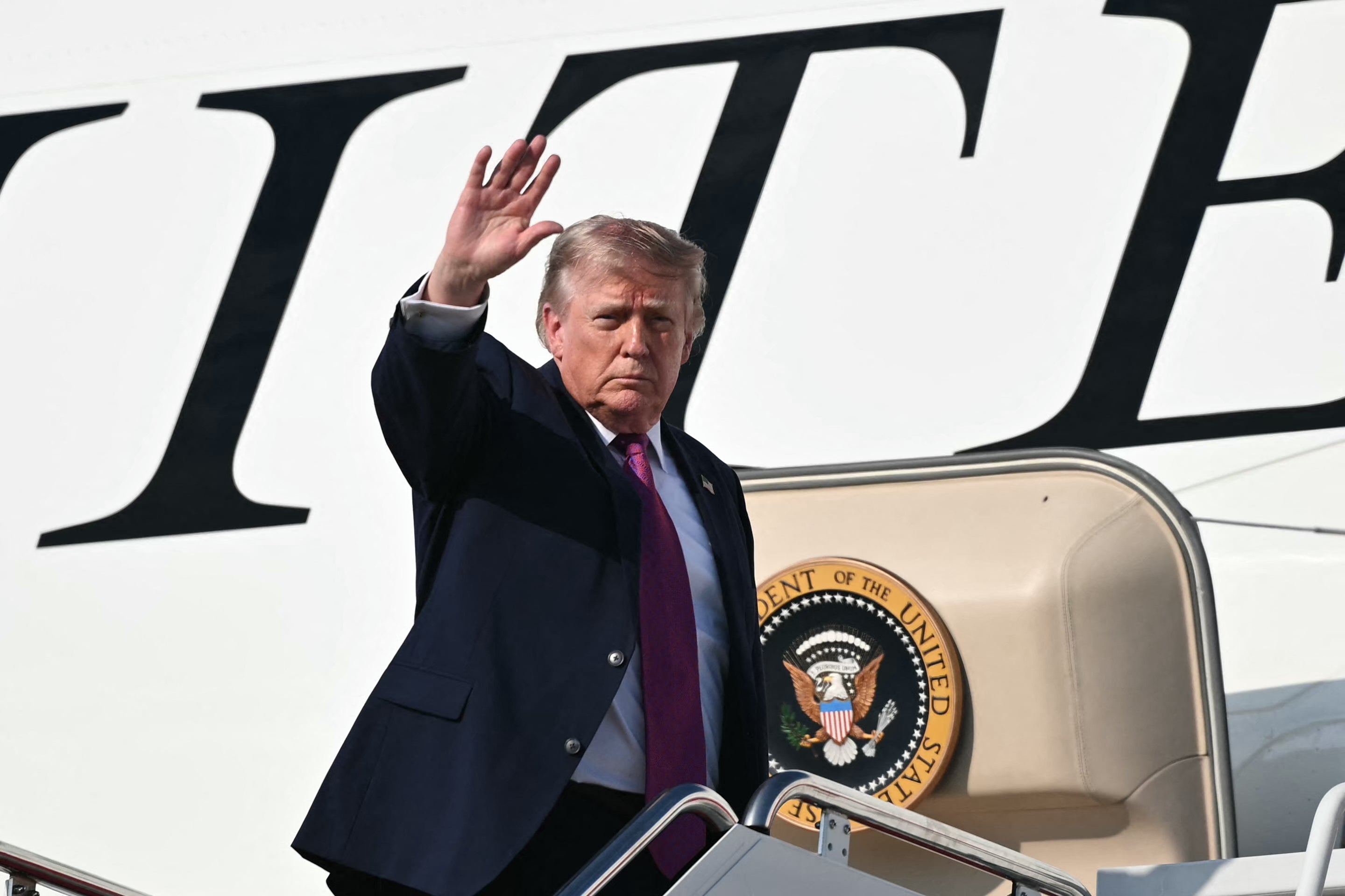 Trump waves as he boards Air Force One