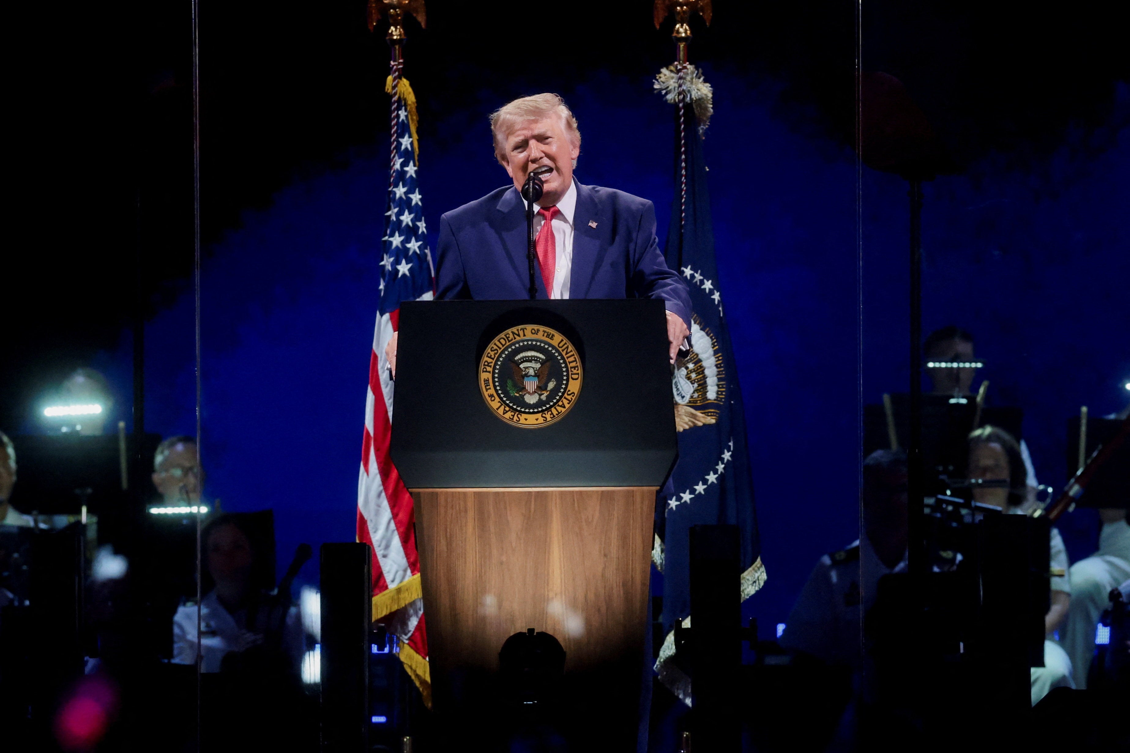 Trump took some partisan shots, hitting out against communism and demanding a voter ID law as he spoke about America’s might
