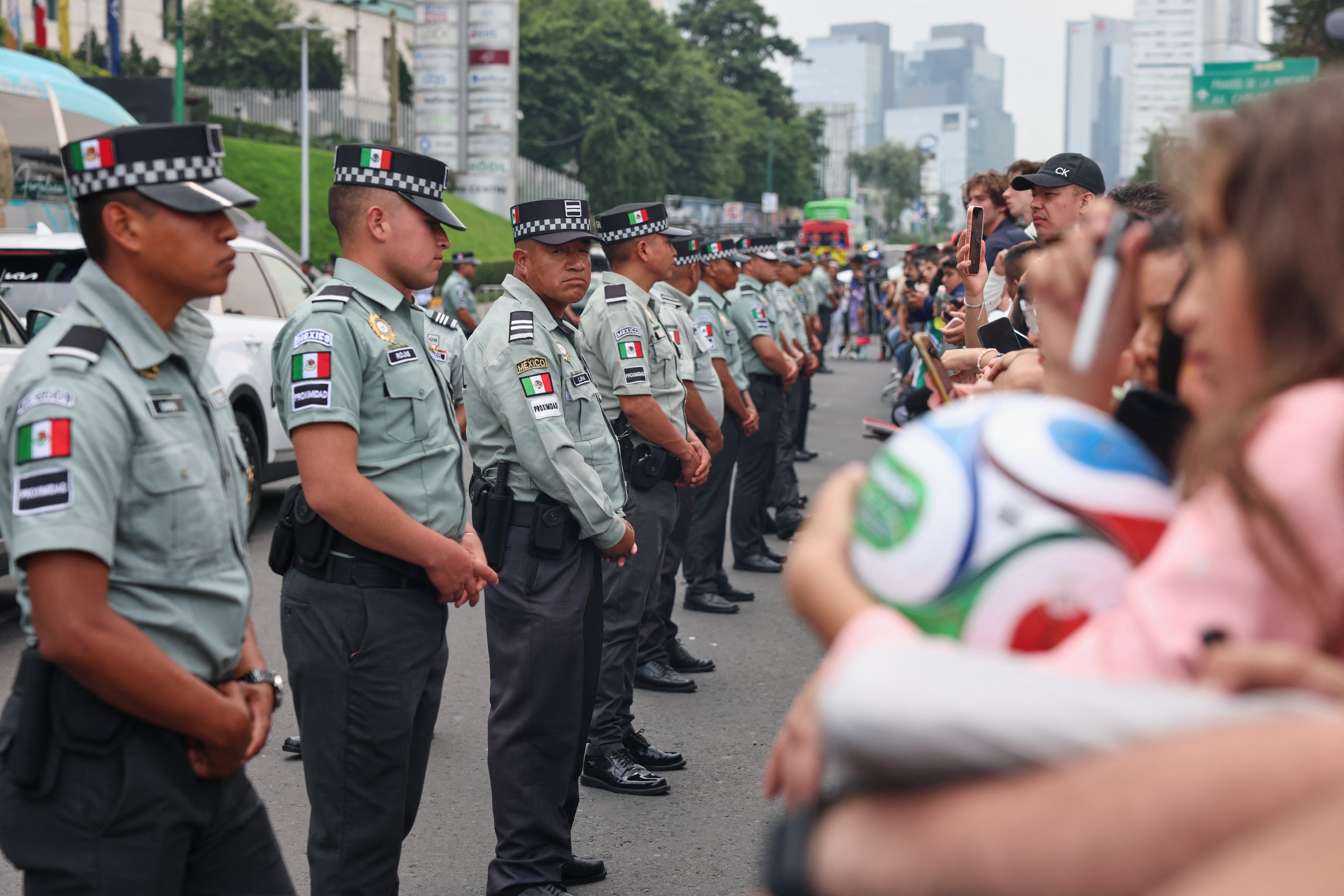 National guardsmen stand between fans and the bus that will take England national football team players to training from the Marriott Hotel