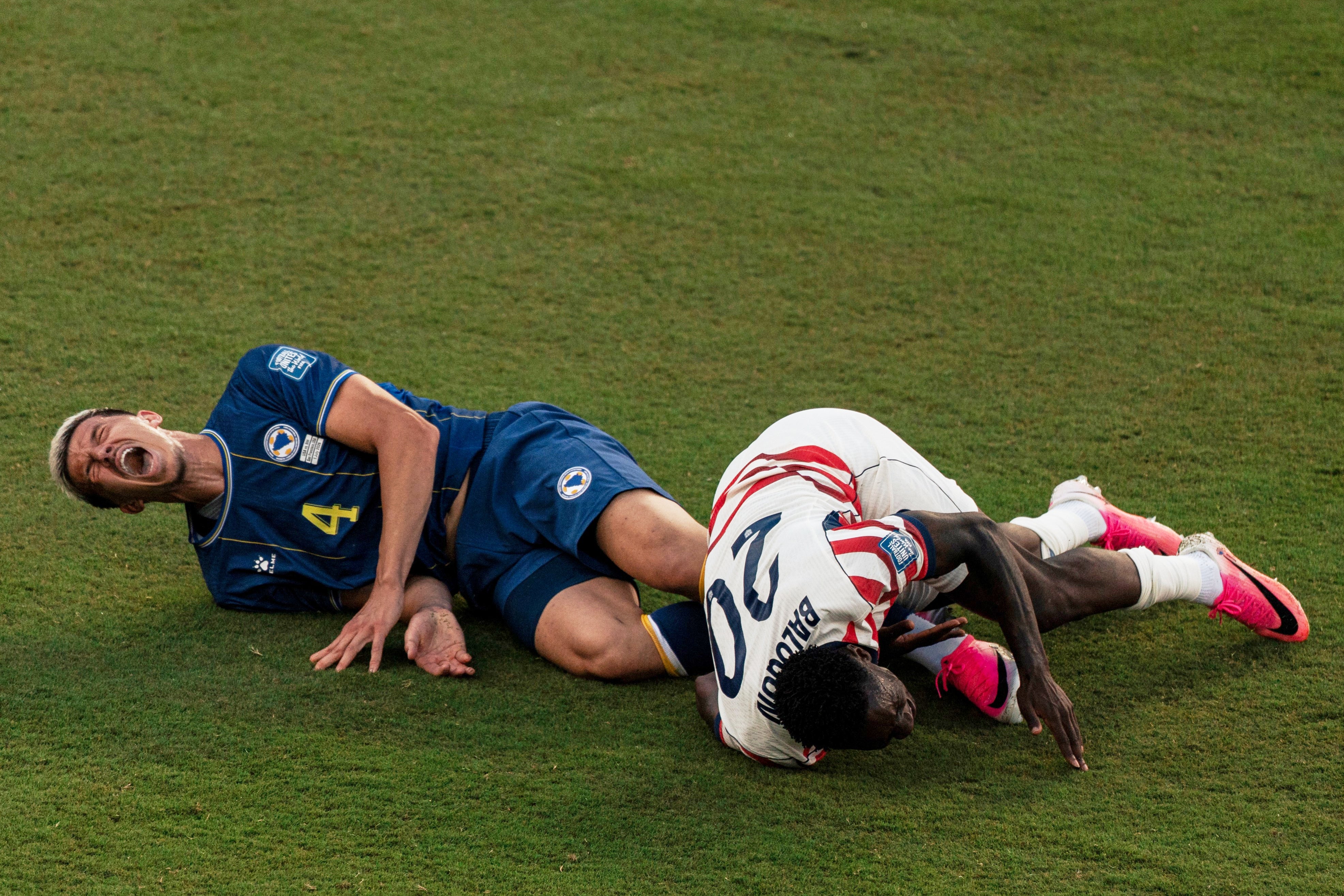 United States' Folarin Balogun (20) and Bosnia's Tarik Muharemovic (4) react after Balogun fouled Muharemovic during the World Cup round of 32 soccer match between the United States and Bosnia in Santa Clara