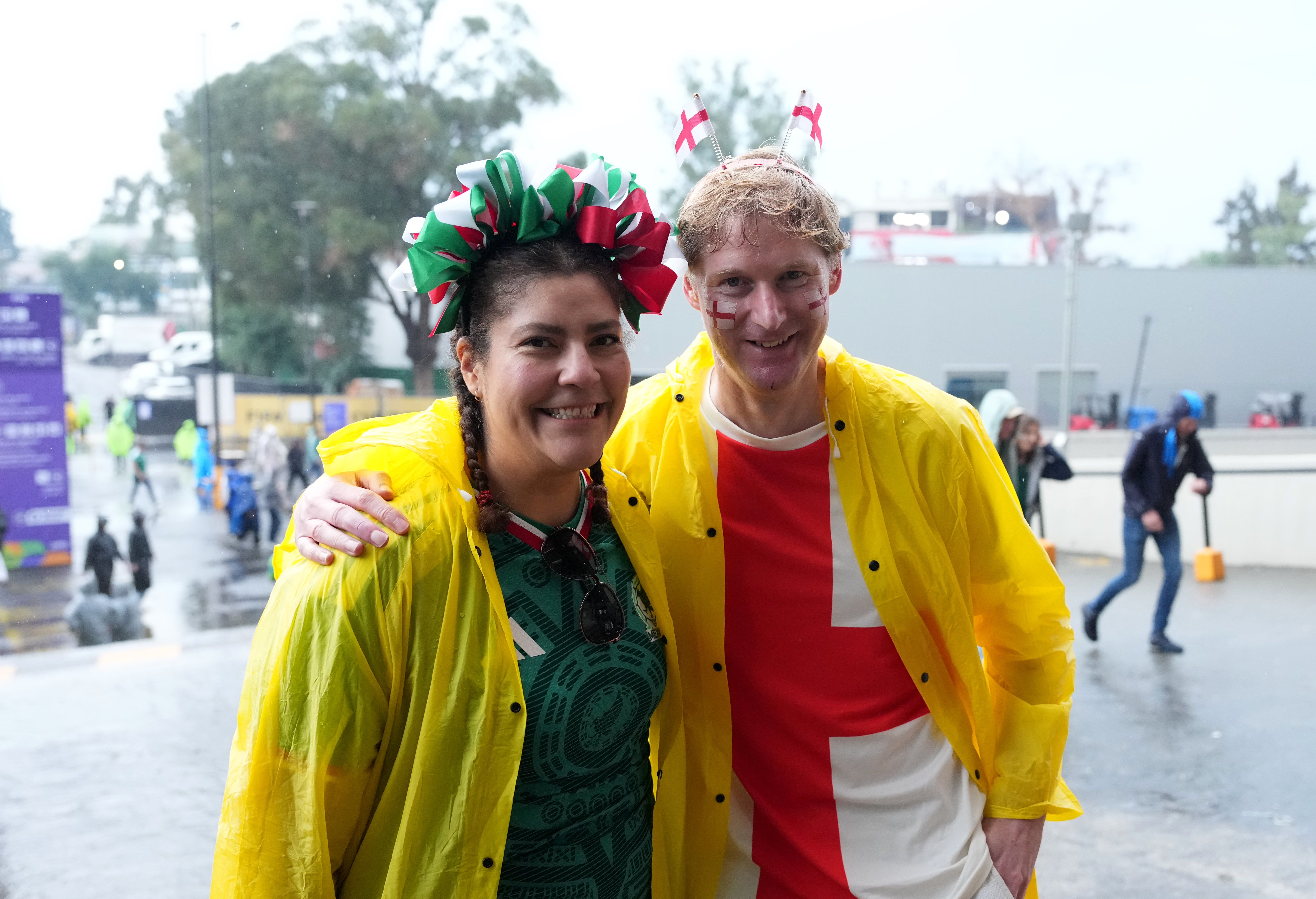 A Mexico fan and an England fan in raincoats ahead of the game (Martin Rickett/PA) (PA Wire)