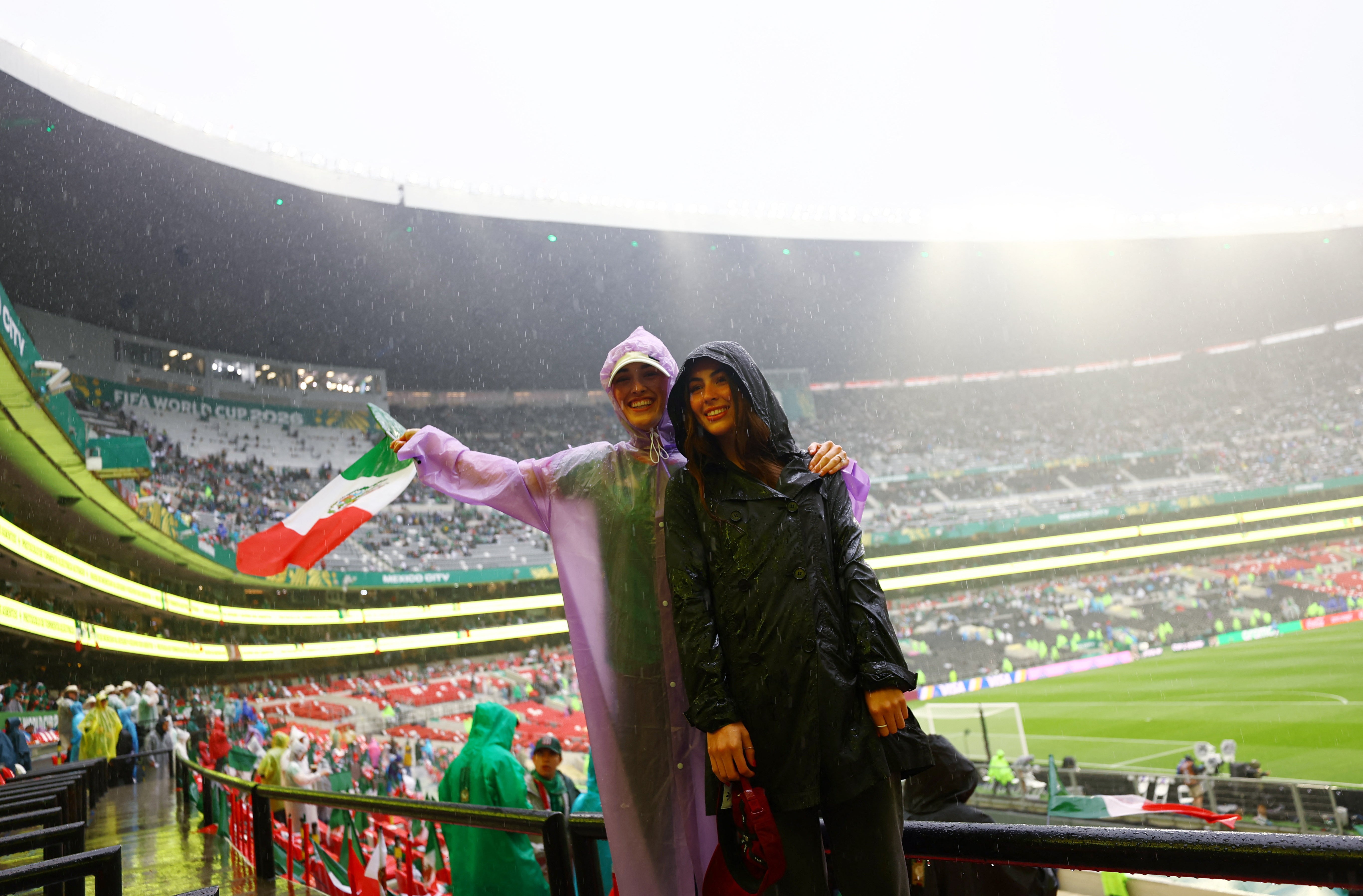 Mexico fans wear rain ponchos inside the stadium before the match after kick off has been delayed due to the weather REUTERS/Daniel Becerril