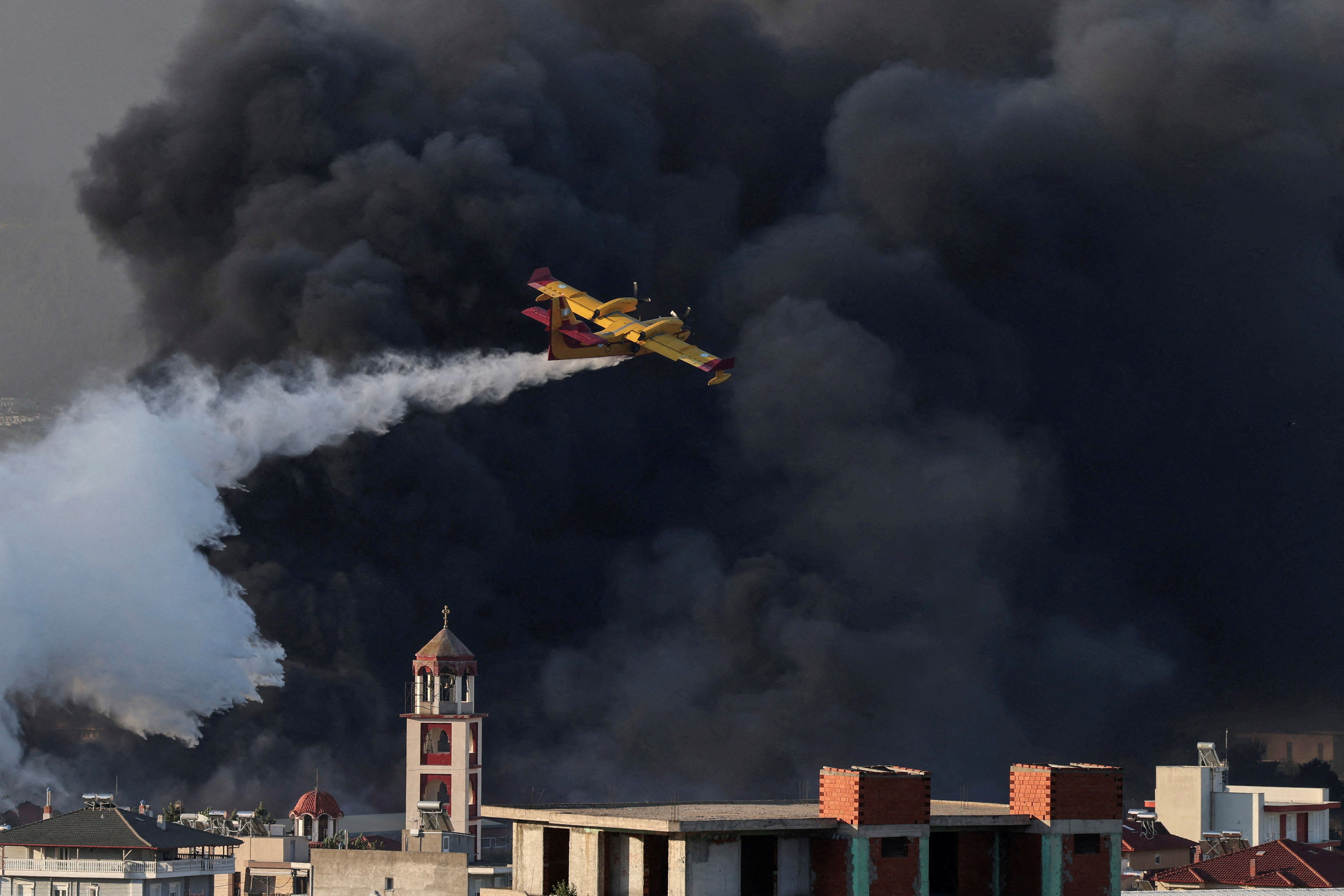 A Canadair firefighting plane drops water at a burning recycling factory in Oreokastro, on the outskirts of Thessaloniki, Greece, July 5, 2026. REUTERS/Alexandros Avramidis