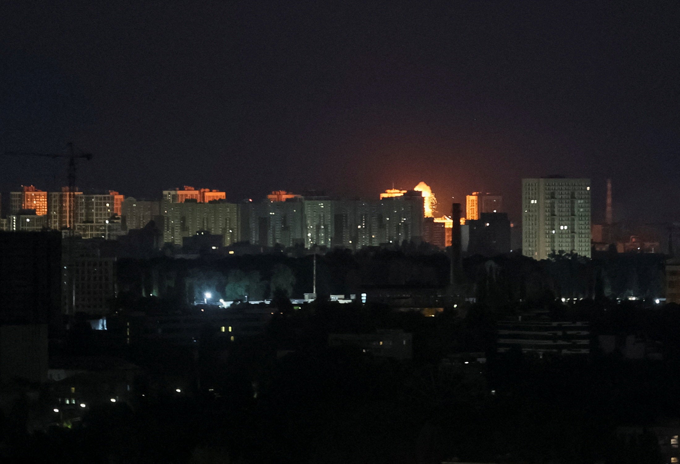 An explosion lights up the sky over the city during a Russian missile and drone strike in Kyiv