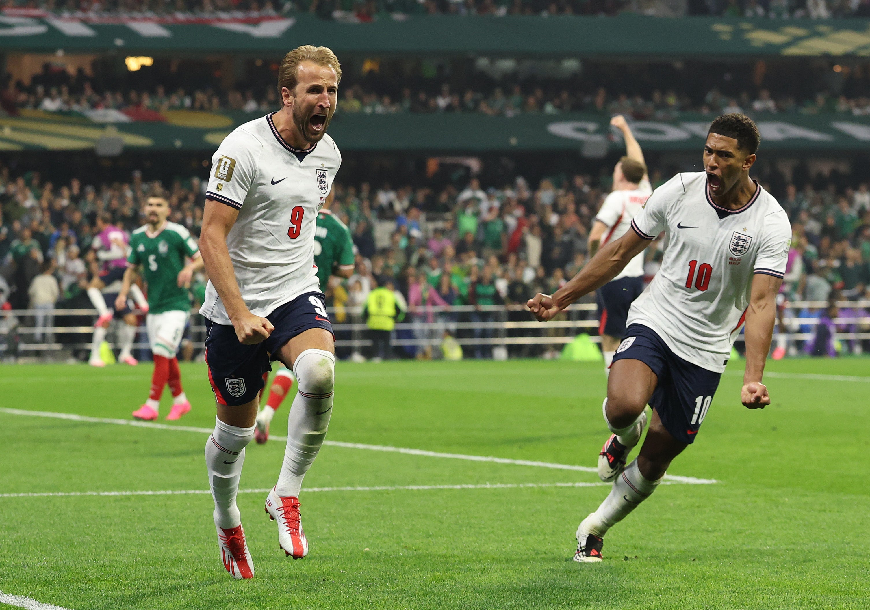 Harry Kane of England celebrates with Jude Bellingham after converting a penalty