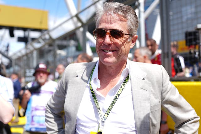Hugh Grant caught in awkward F1 grid walk chat over Netflix series | The Independent