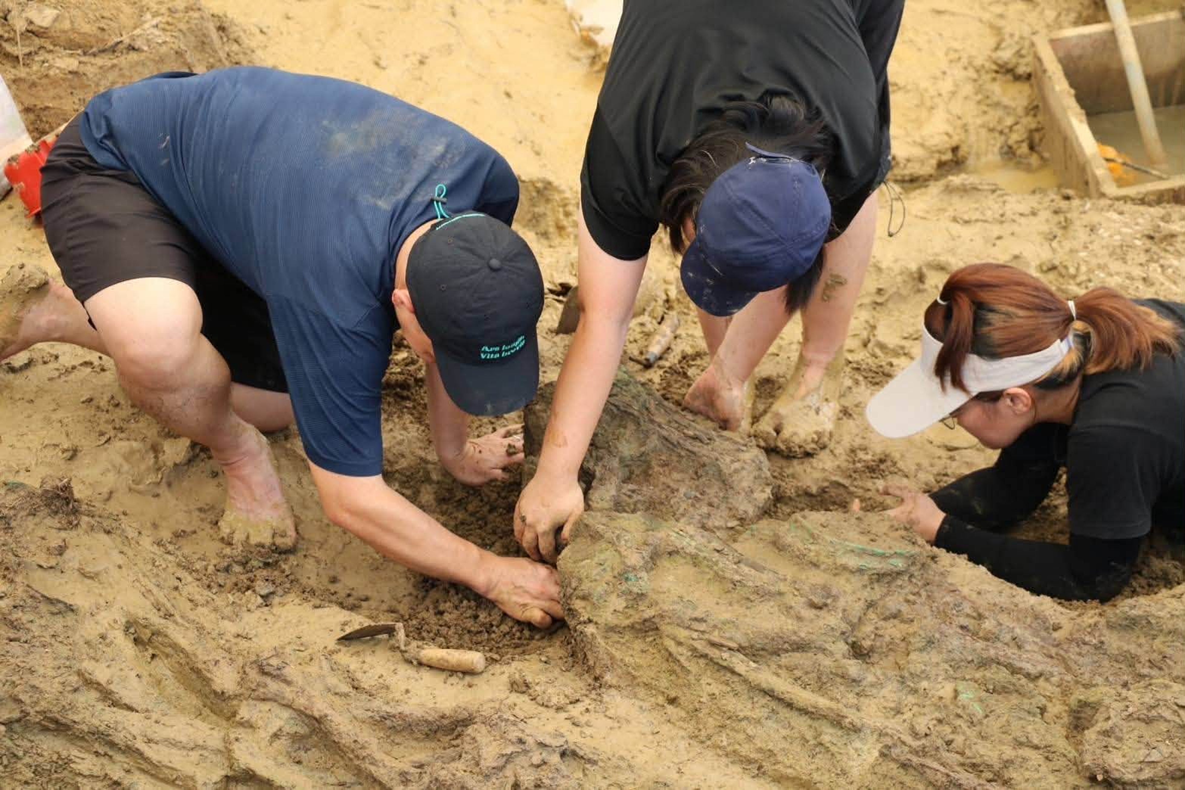 Archäologen werden während einer laufenden Ausgrabung an der archäologischen Stätte Don Yai Thong in der thailändischen Provinz Phetchaburi mit menschlichen Knochen abgebildet