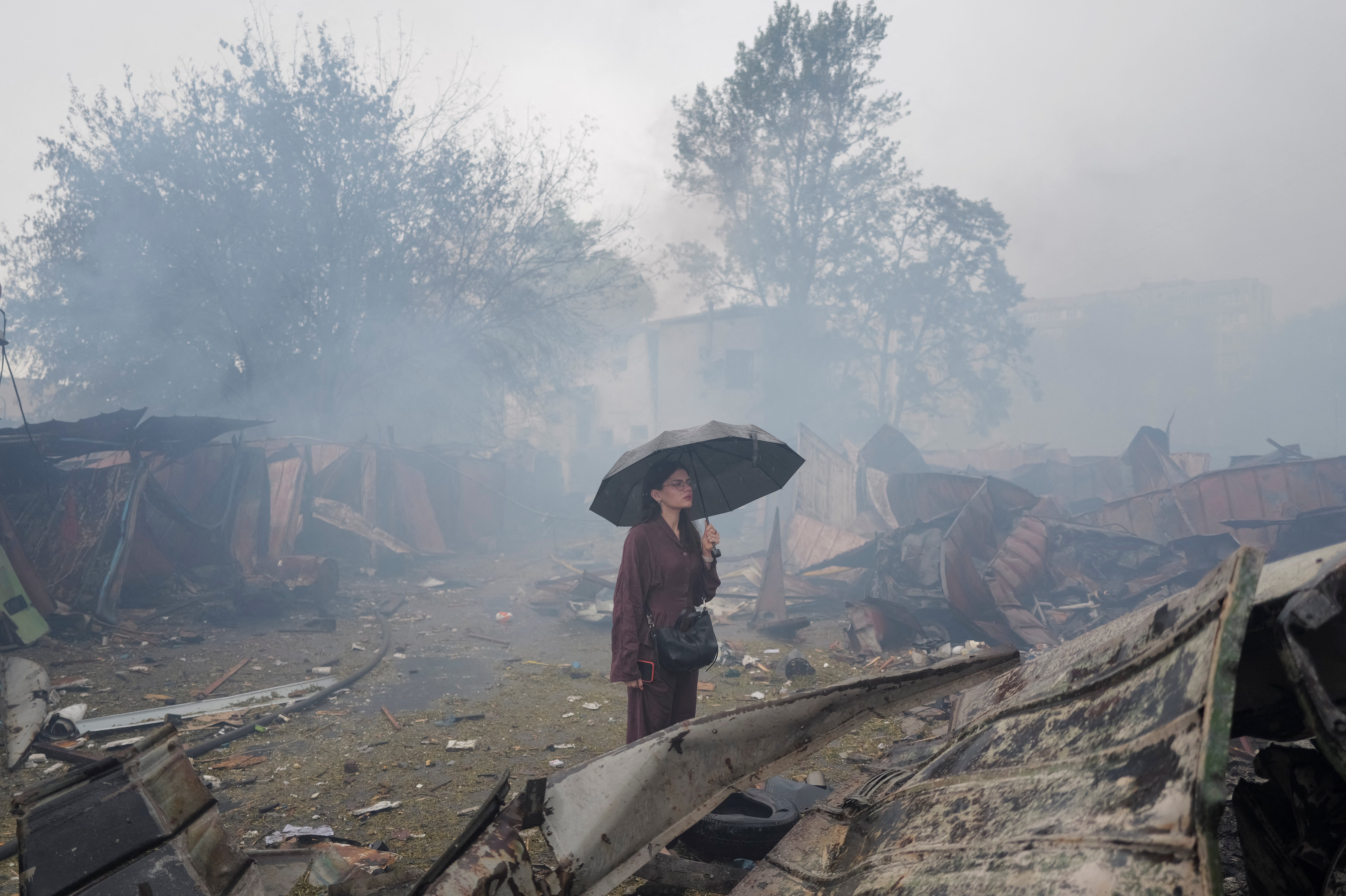 A resident stands at a site of a Russian missile and drone strikes on the outskirts of Kyiv on Monday (Reuters)